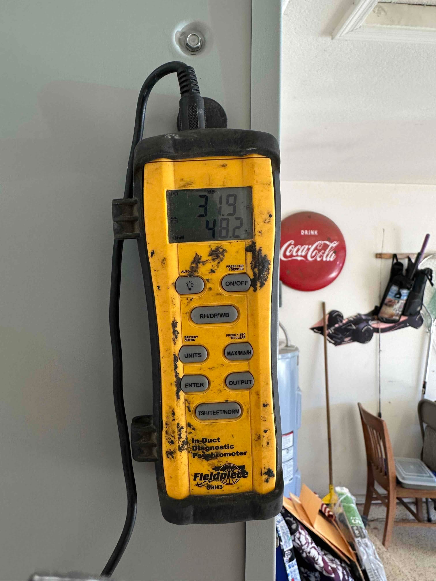 Digital in-duct thermometer/hygrometer displays 31.9 and 48.2 on the screen during air-side checks at the air handler.