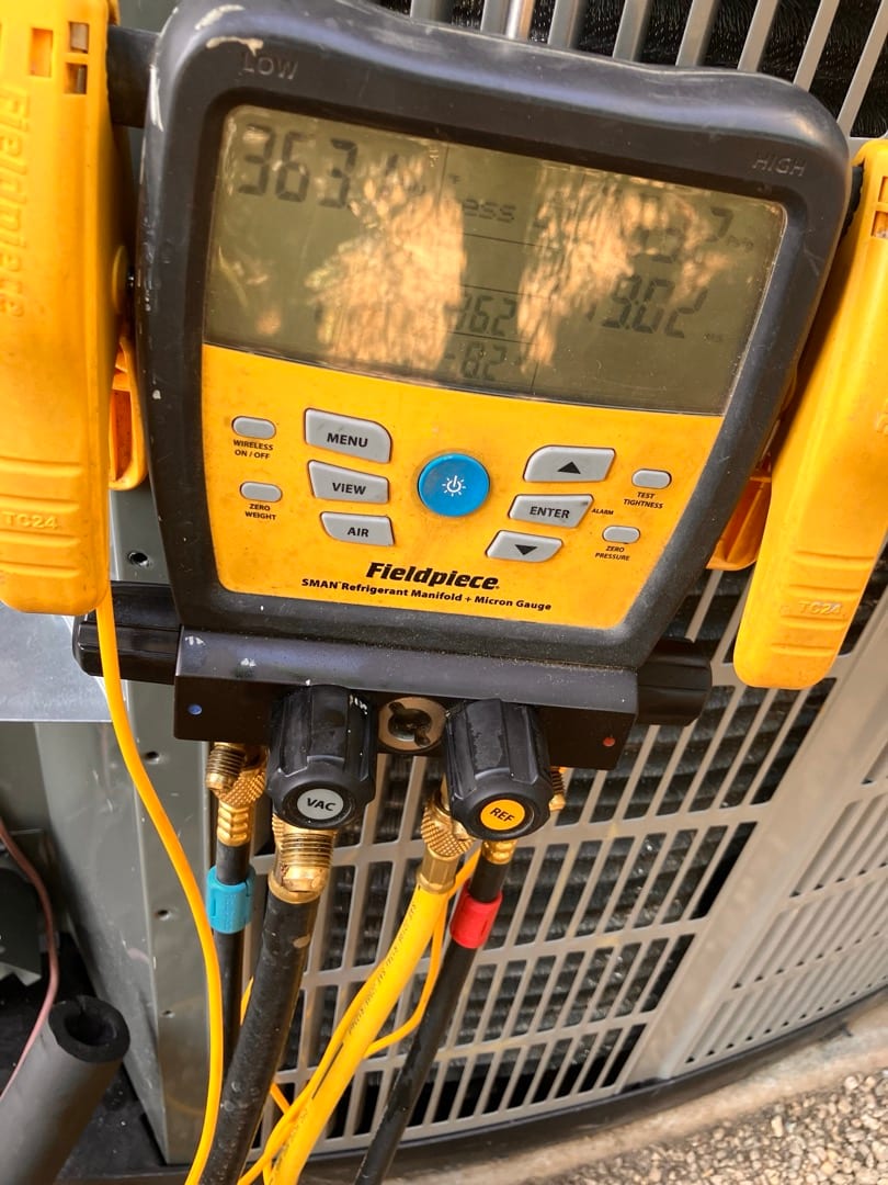 Digital manifold shows both high and low sides holding equal pressure during the nitrogen pressure test on the new outdoor unit.