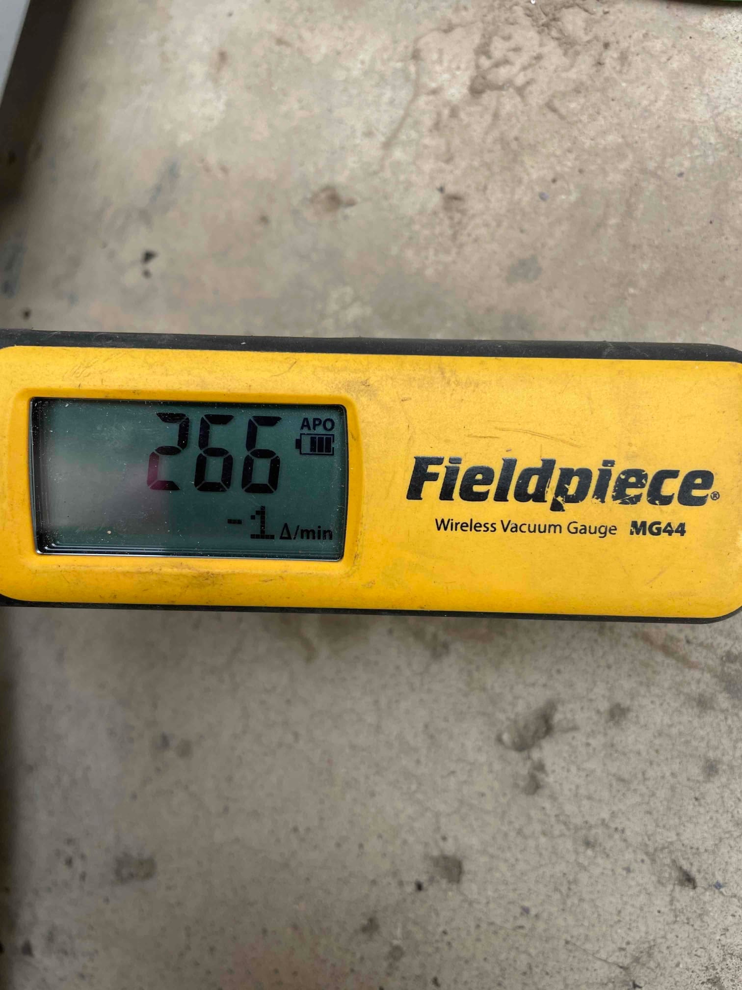 Digital micron gauge displays 266 microns with a stable decay rate during the evacuation phase before refrigerant charging.