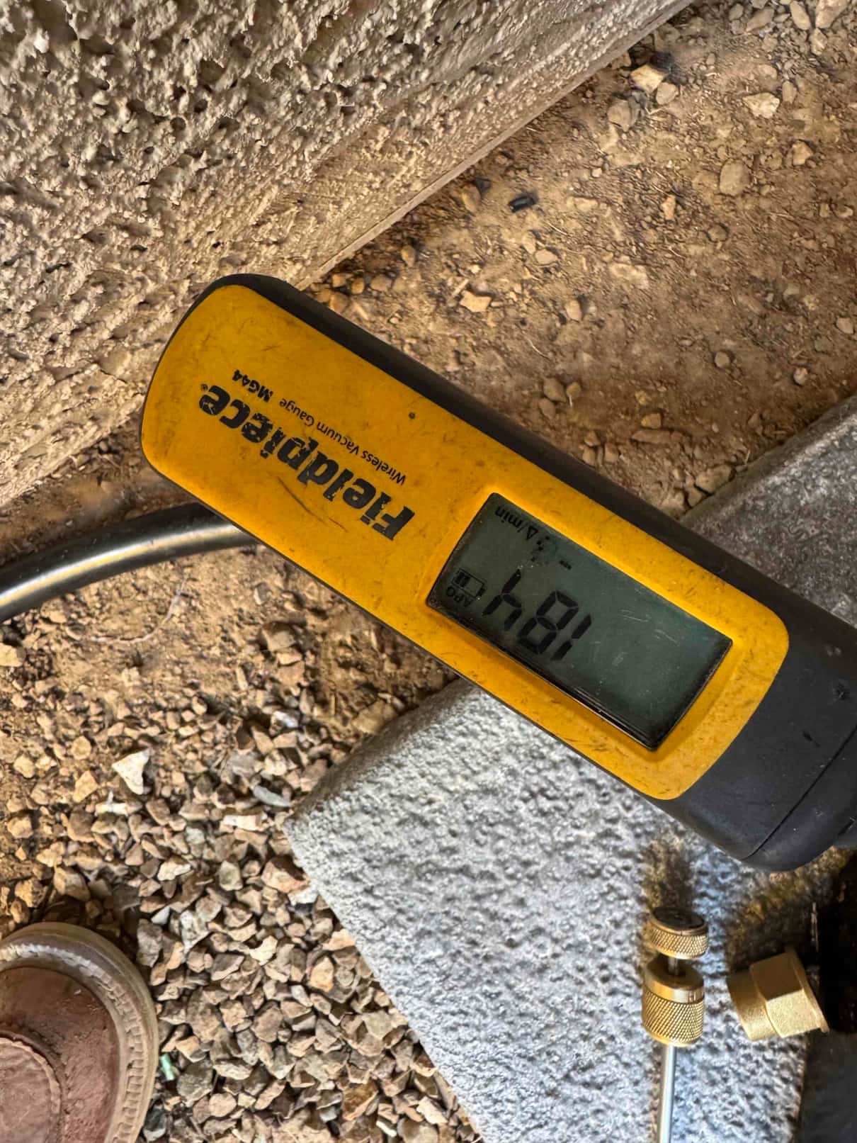 Digital micron gauge shows 481 microns during evacuation, confirming a deep vacuum on the new HVAC system.