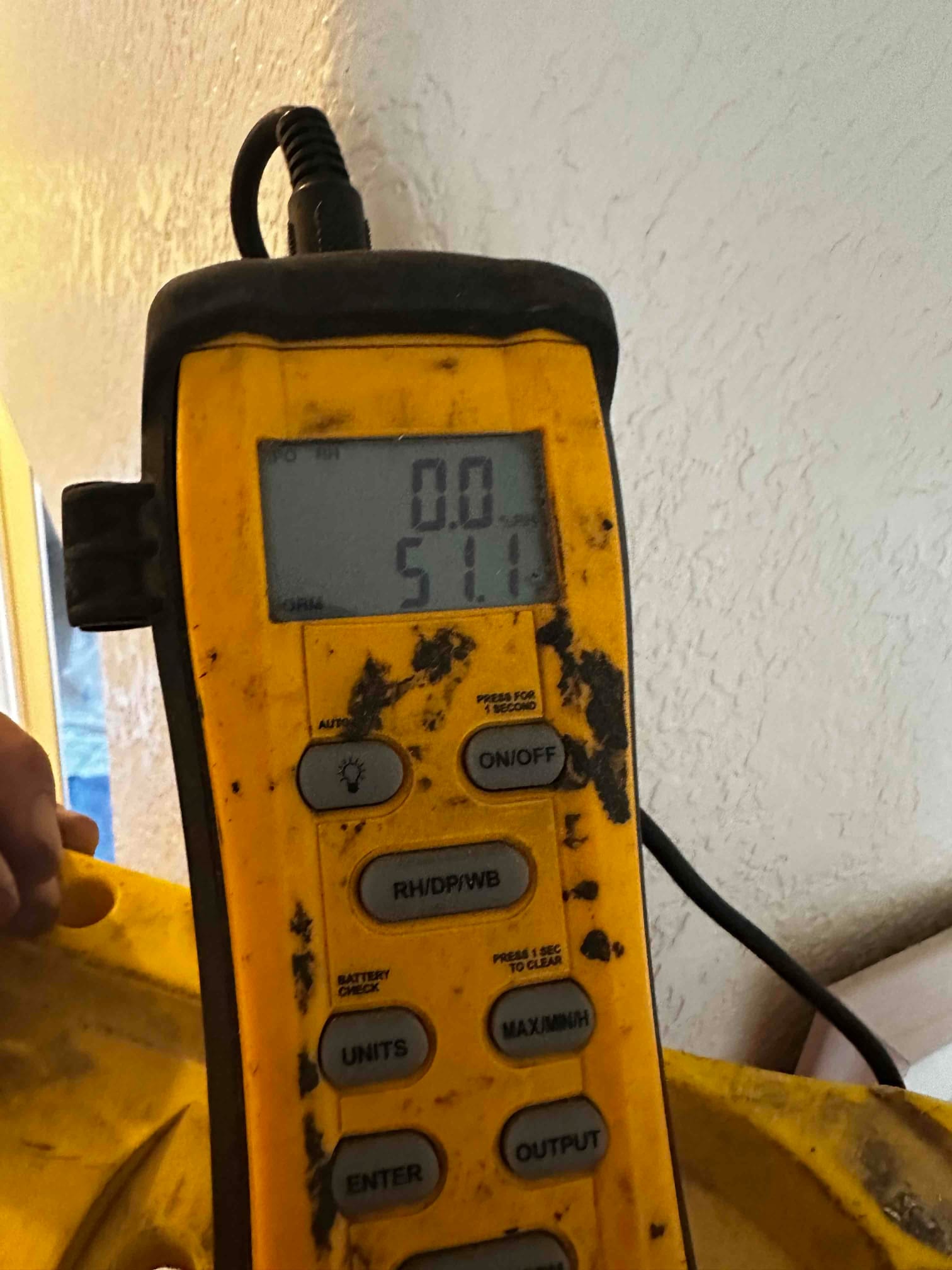 Digital thermometer displays 51.1 degrees Fahrenheit during supply air temperature check at the new installation.