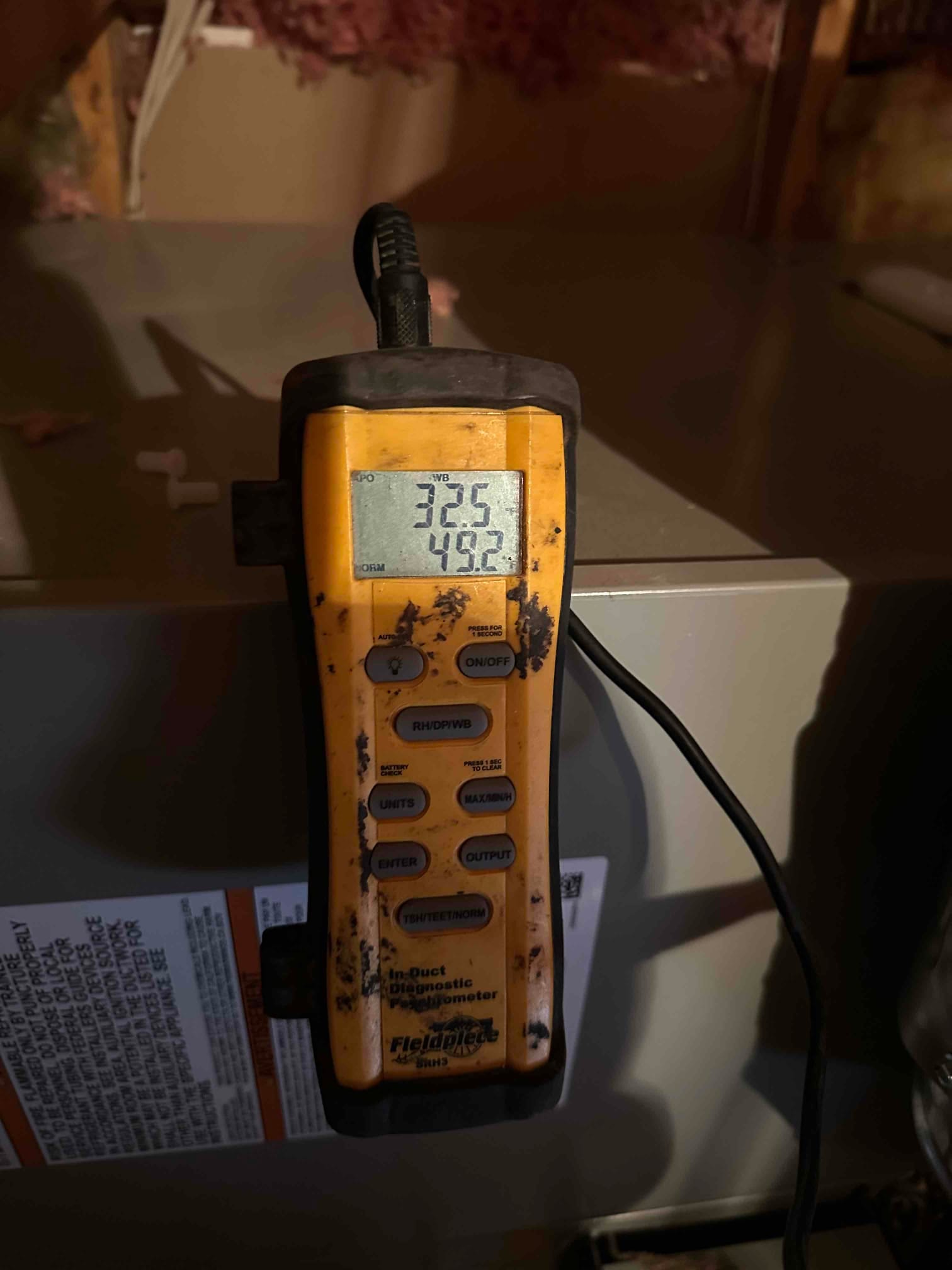 Digital thermometer mounted on the furnace cabinet displays 32.5 and 49.2 degrees during air-side measurements.