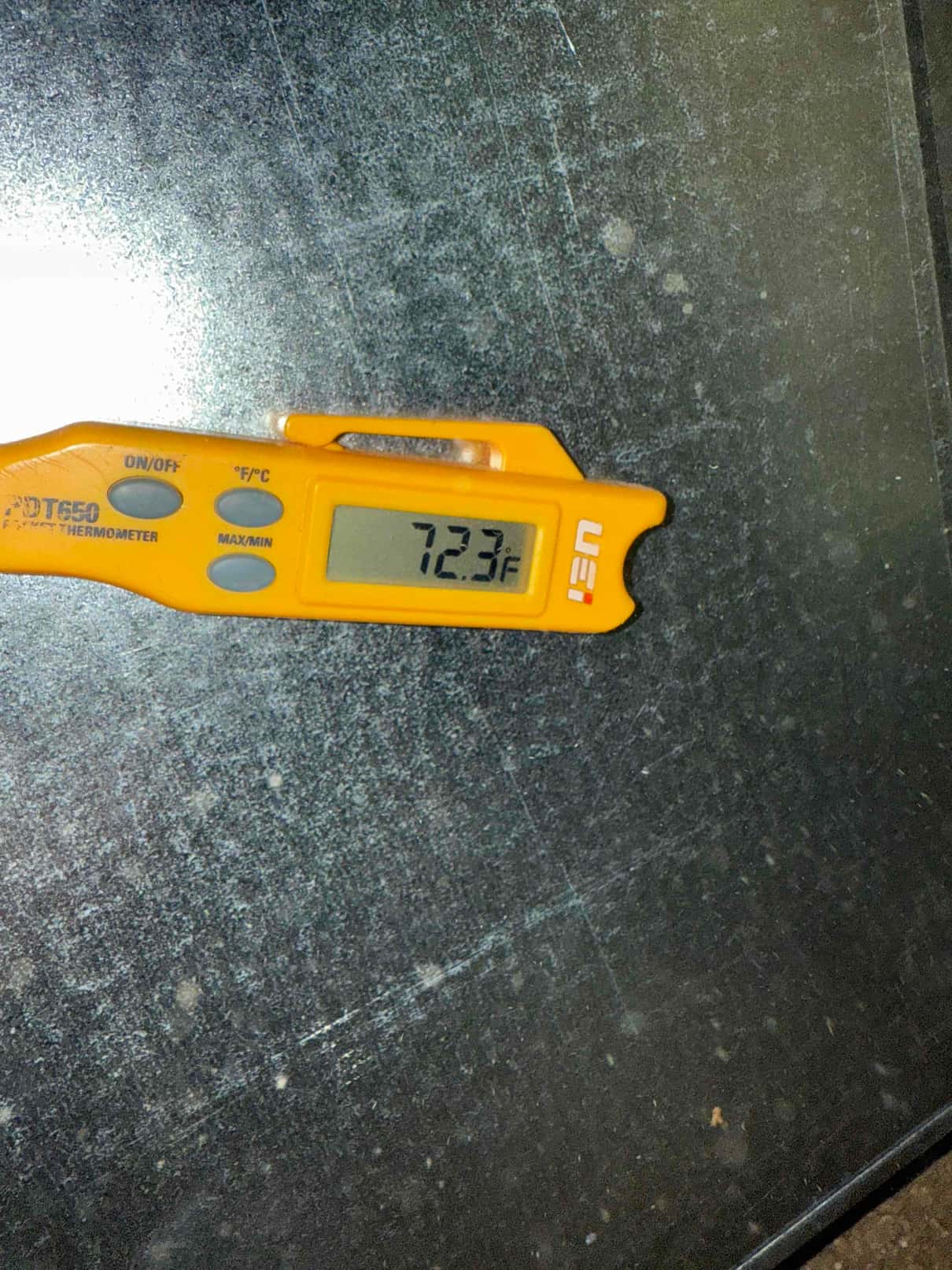 Digital thermometer shows 72.3°F while measuring air temperature during return-side check on the HVAC installation.