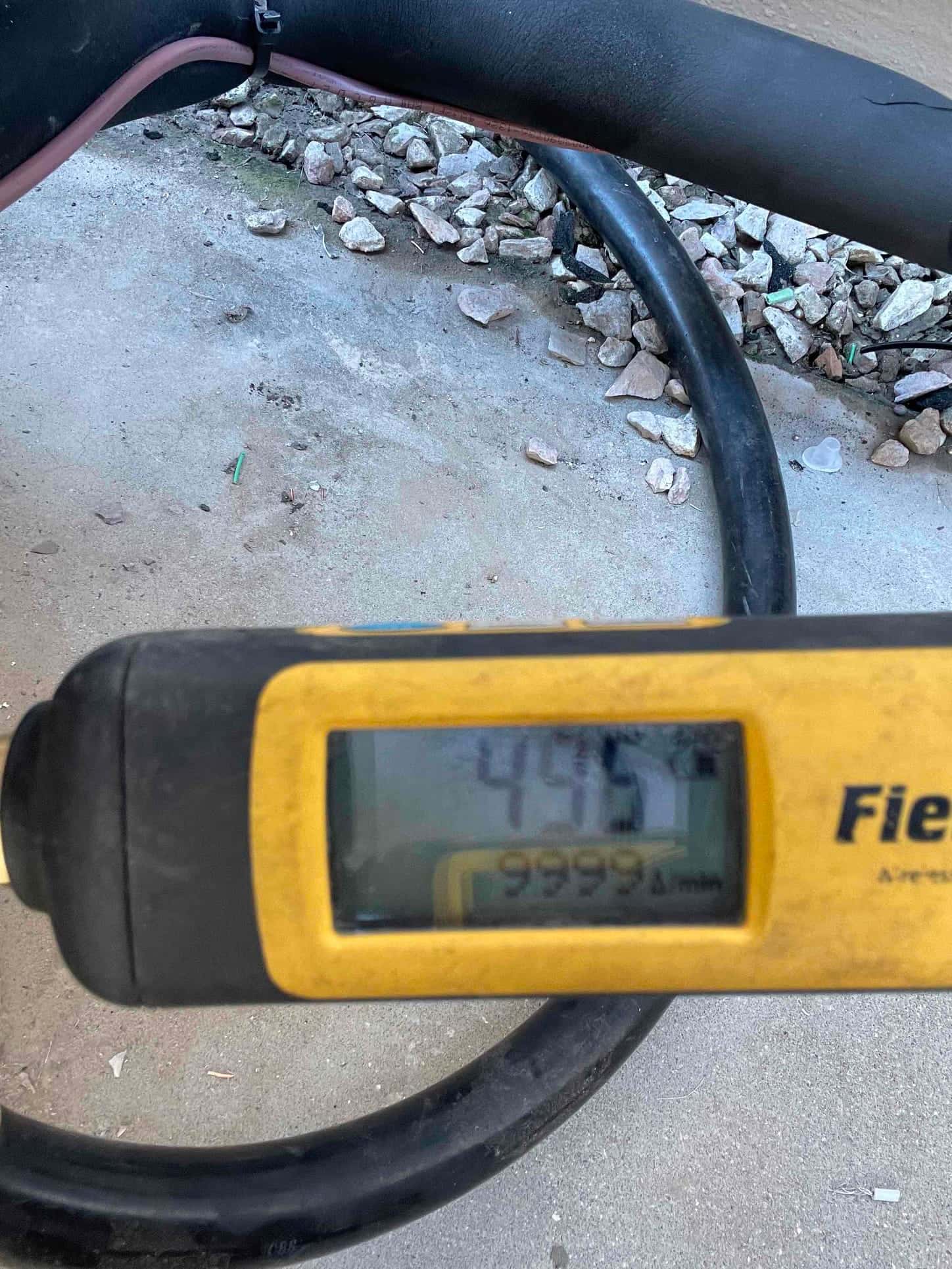 Micron gauge displays 445 microns during system evacuation, confirming a deep vacuum before releasing refrigerant into the lines.
