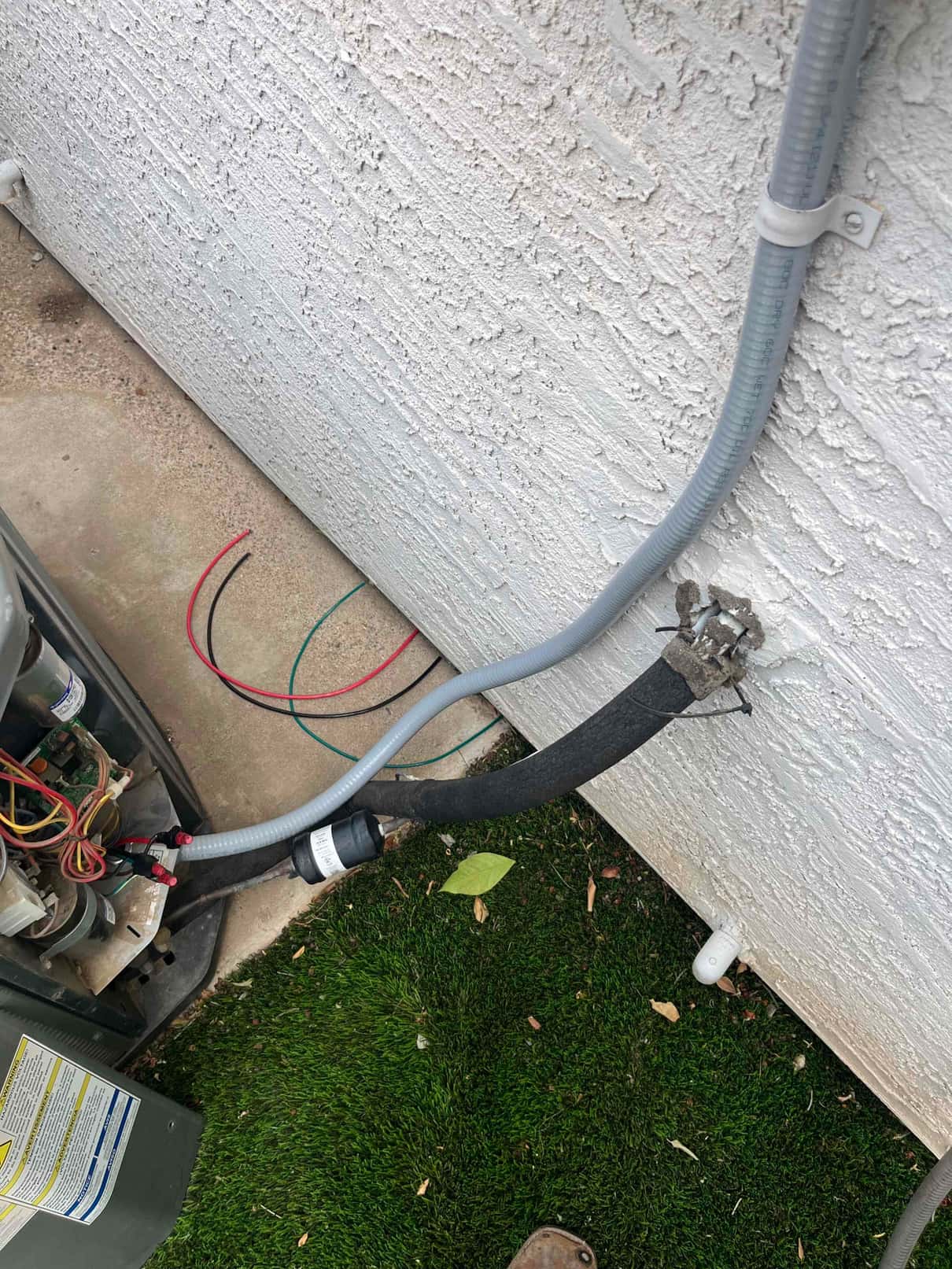New condenser whip and start assist installed at outdoor unit, with wiring secured and insulation on the refrigerant line.