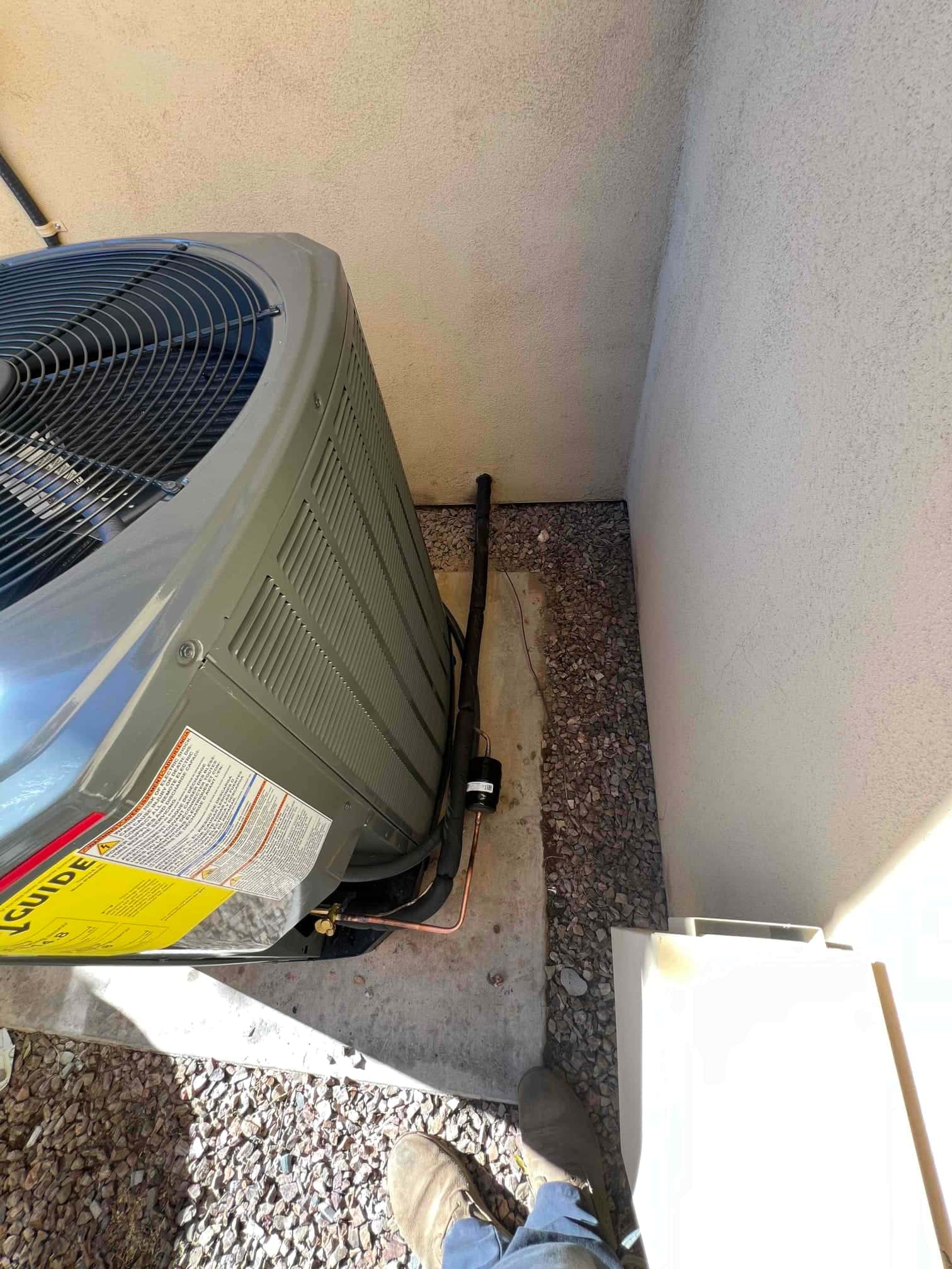 Outdoor heat pump condenser set on a level pad with insulated line set and filter drier installed on the liquid line.