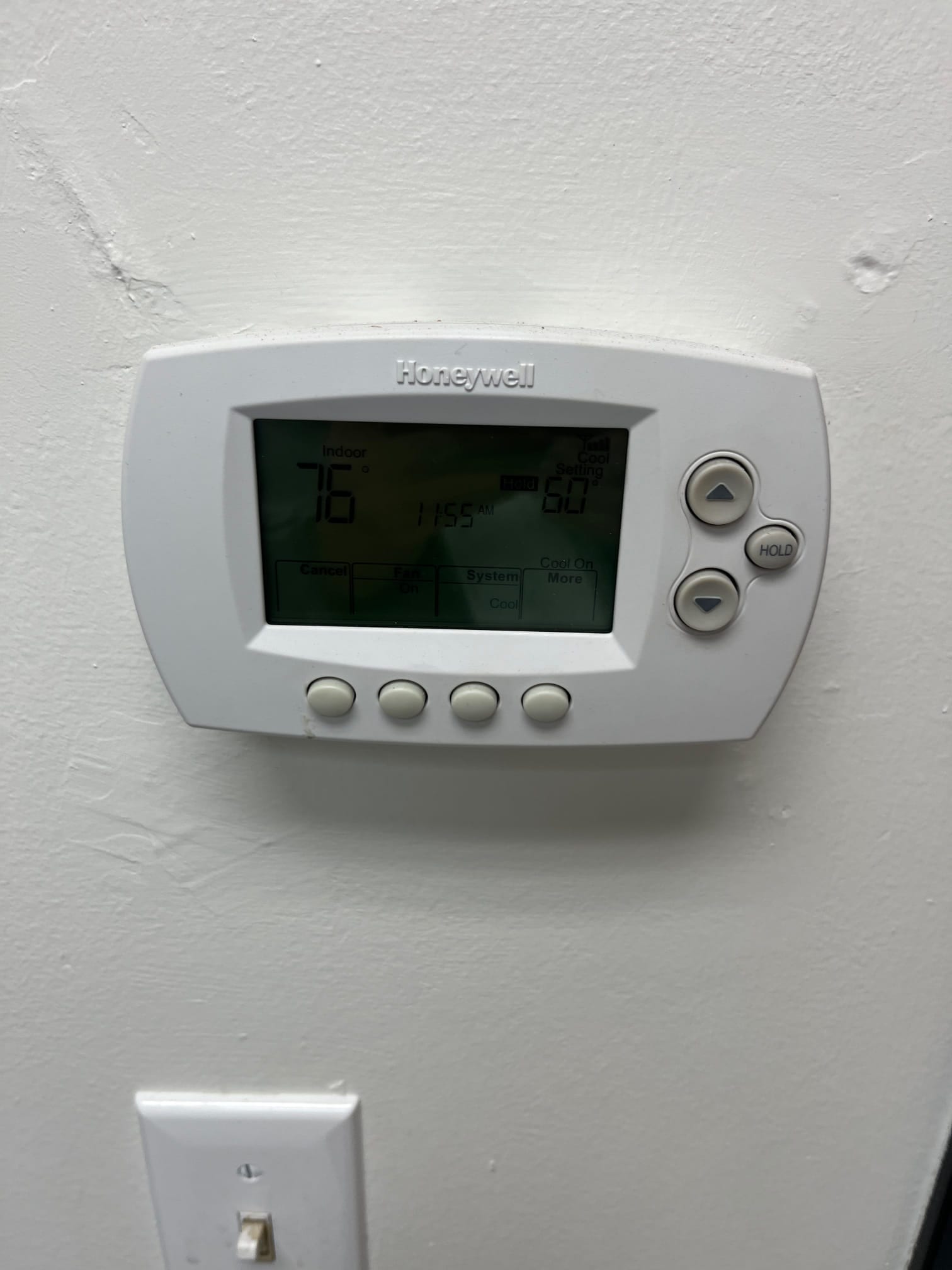 Wall-mounted thermostat display shows indoor temperature at 76 and cool setpoint at 60, with system set to cool.