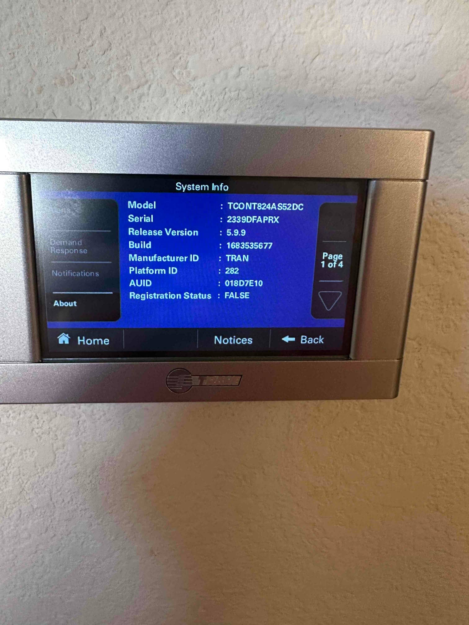 Wall-mounted thermostat displays a system information screen during setup after installing the new heat pump system.