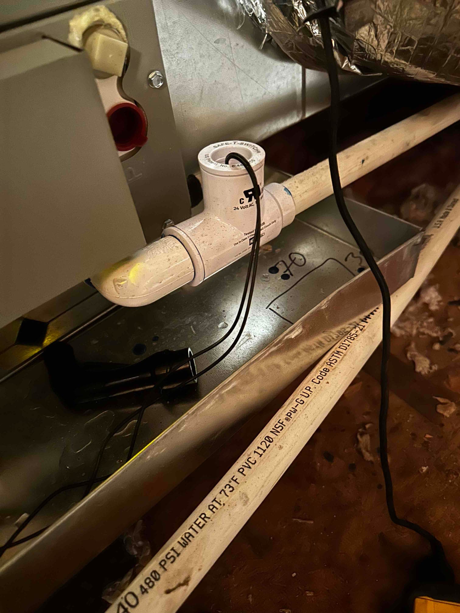 Condensate drain with float safety switch wired in on the air handler’s auxiliary pan area inside the attic.