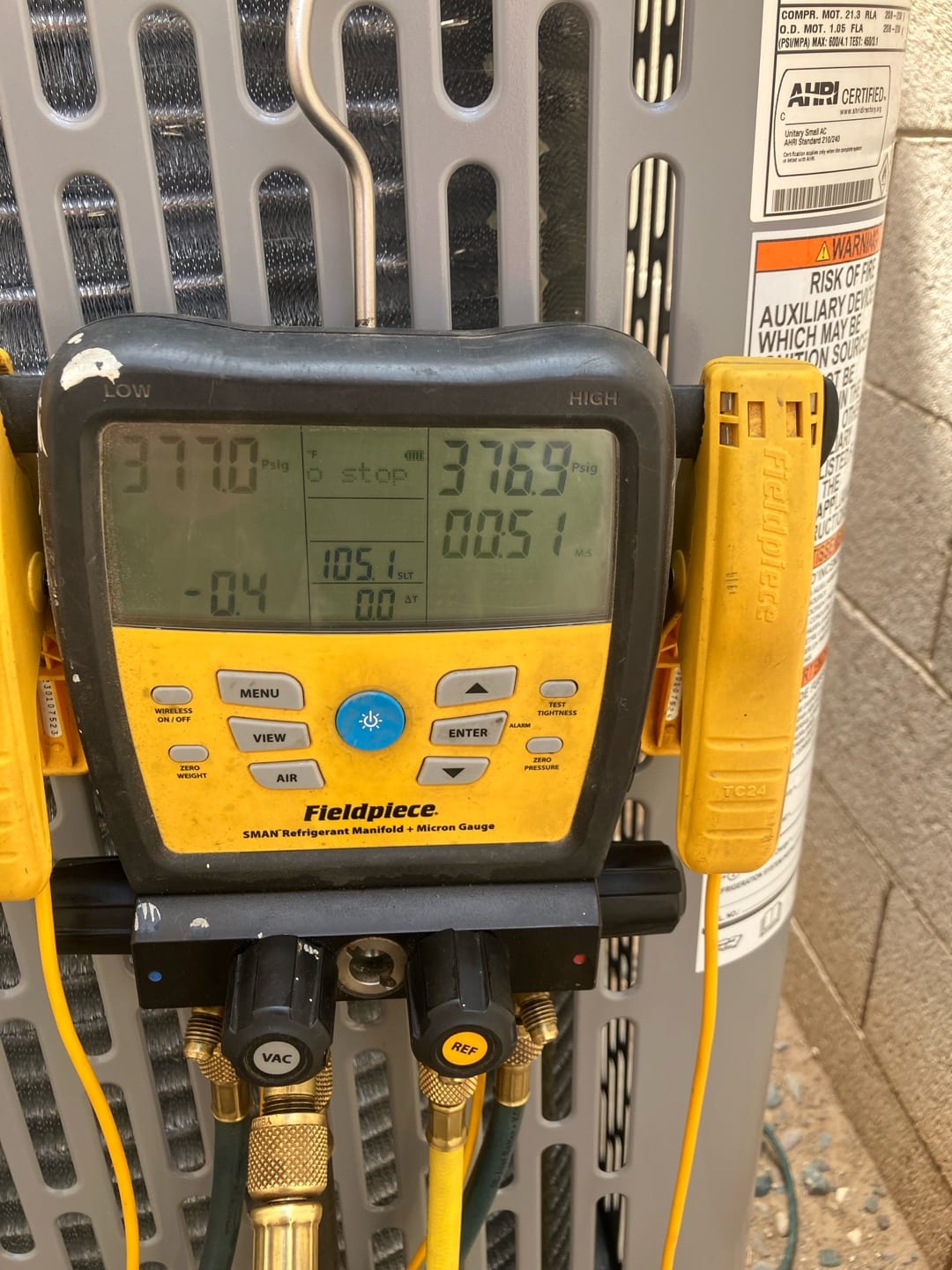 Digital manifold gauges show equal pressures around 377 PSI on both sides during a nitrogen pressure test of the system.