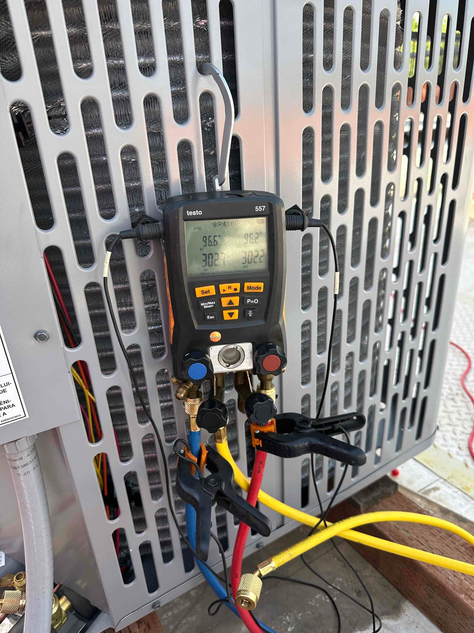Digital manifold gauges connected at the outdoor unit show equal high pressure on both sides during the nitrogen pressure test.