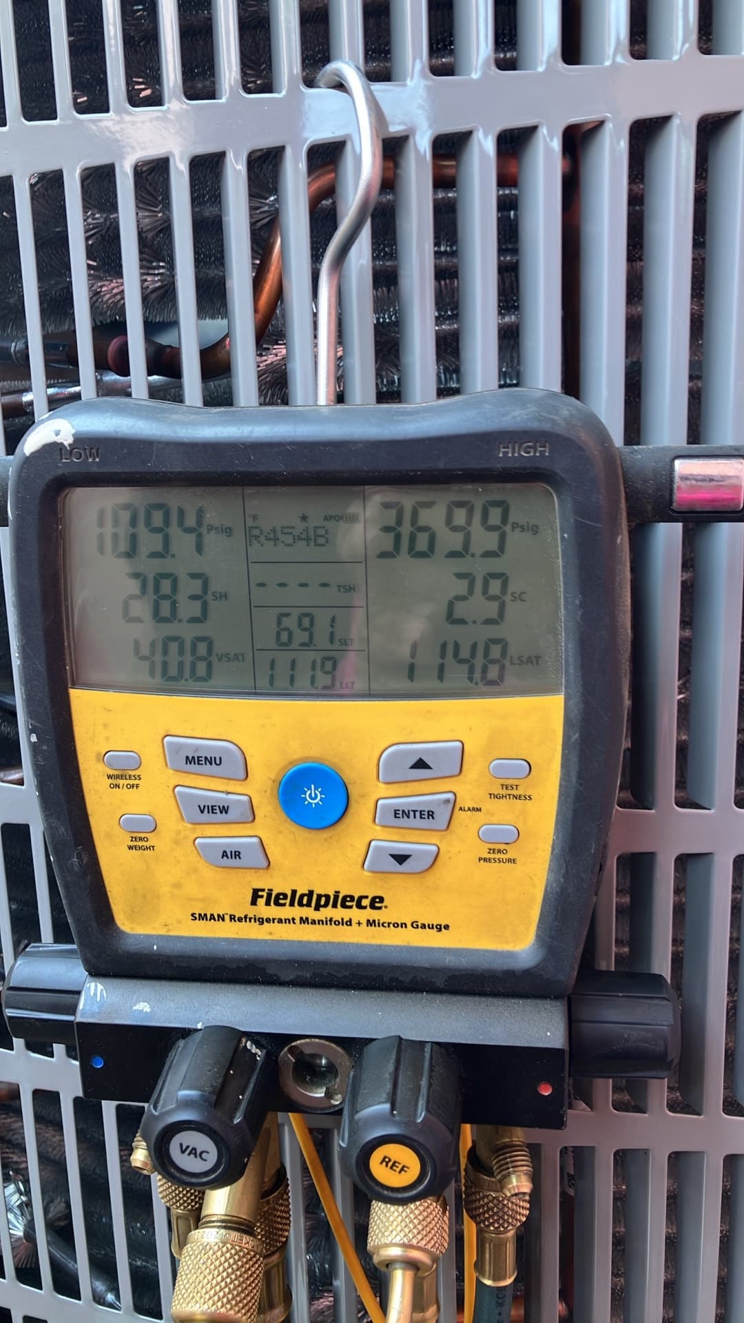 Digital manifold shows operating pressures with low side at 109 PSI and high side at 370 PSI on an outdoor condenser.