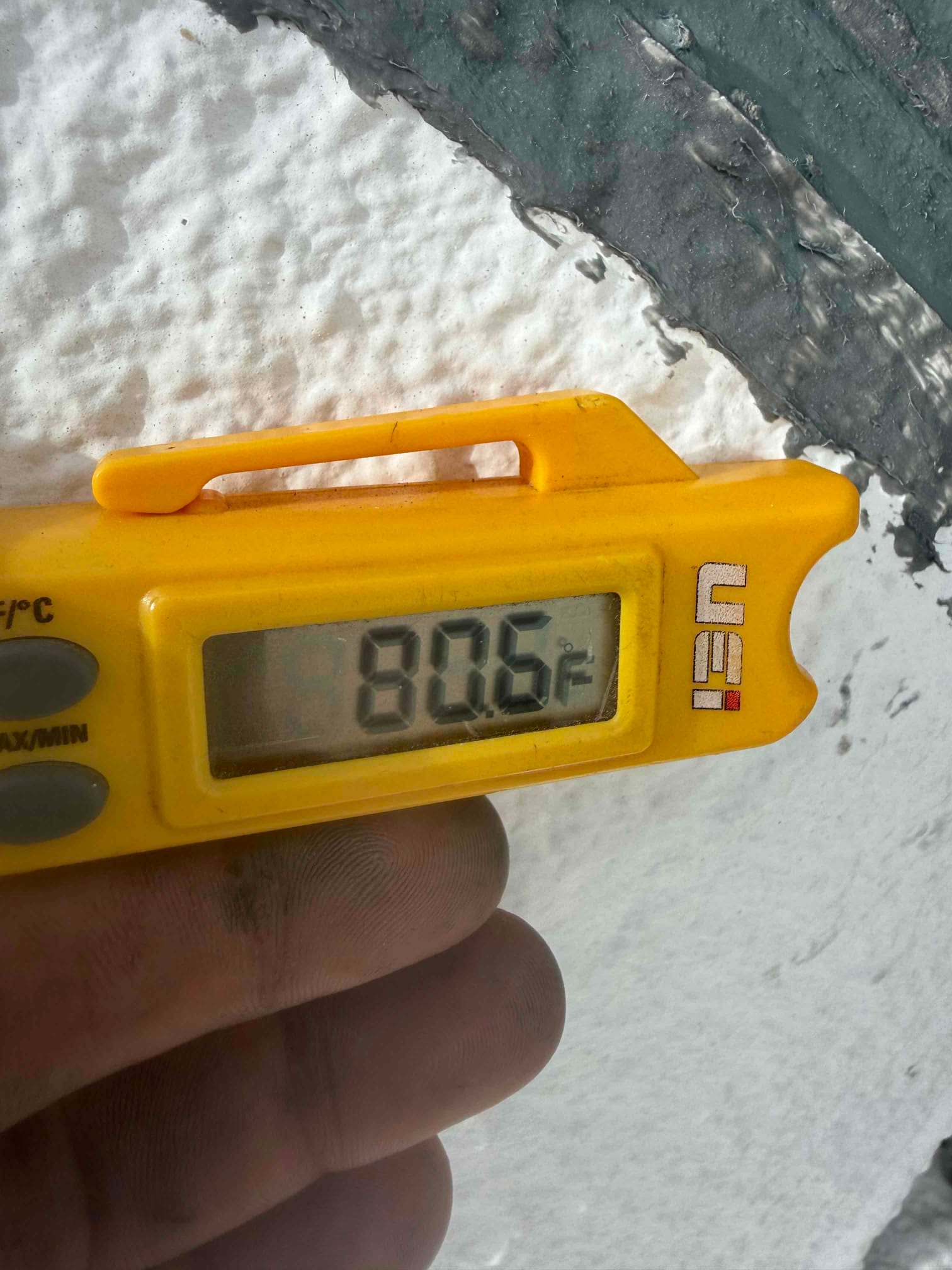 Digital thermometer shows 80.6°F, documenting a warm air reading for return air during commissioning.
