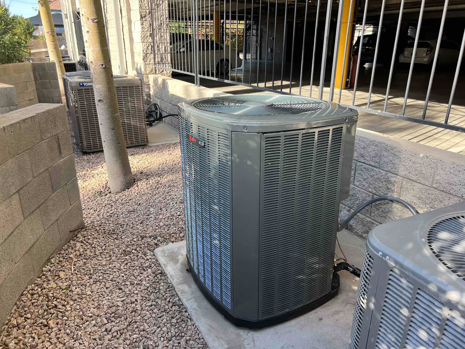New outdoor condensers set on level pads with insulated refrigerant lines routed to the building service area.