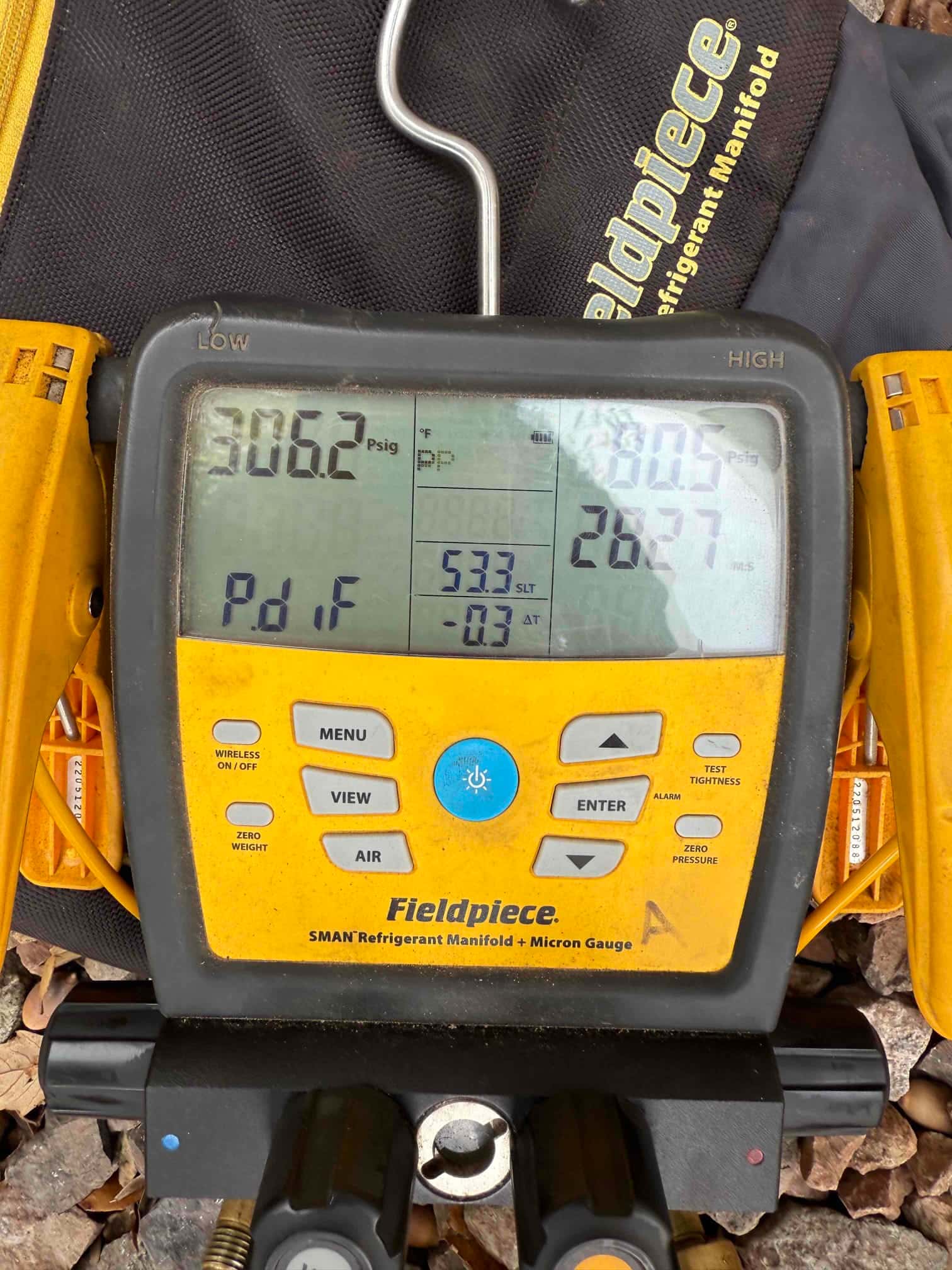 Digital manifold shows system operating pressures with low side at 306 psig and high side at 806 psig during commissioning.