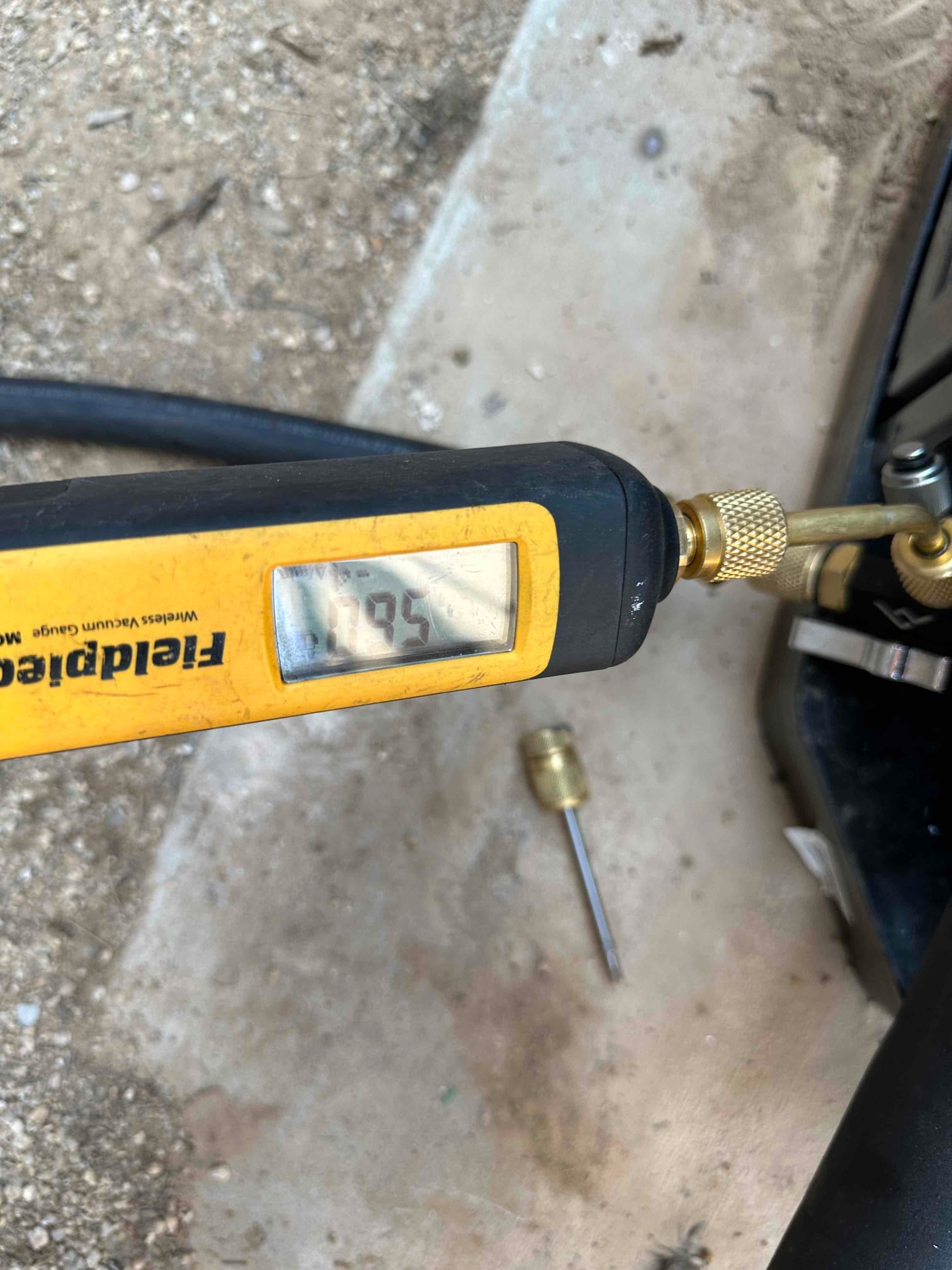 Digital micron gauge connected at the outdoor unit reads 585 microns during system evacuation prior to refrigerant charging.