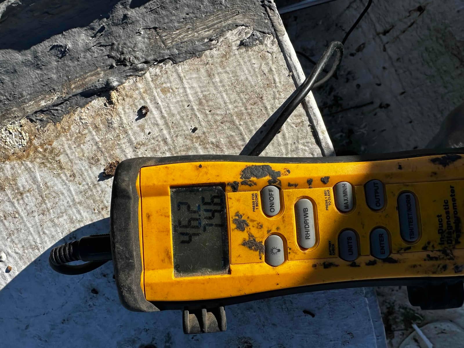 Digital thermometer on site displays two temperature readings during air-side checks of the newly installed system.