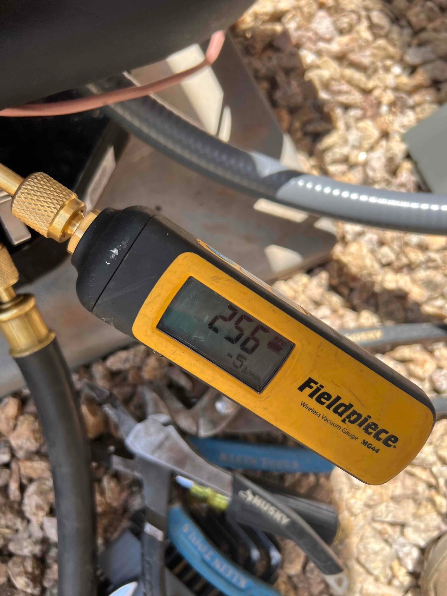 Digital vacuum gauge connected to the system shows 256 microns during evacuation prior to releasing refrigerant.