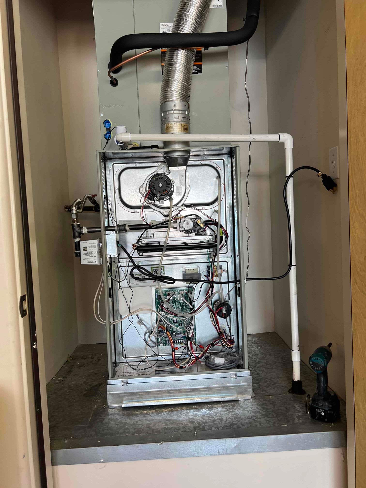 New furnace and evaporator coil installed in a closet, with venting, condensate drain, and control wiring visible during setup.