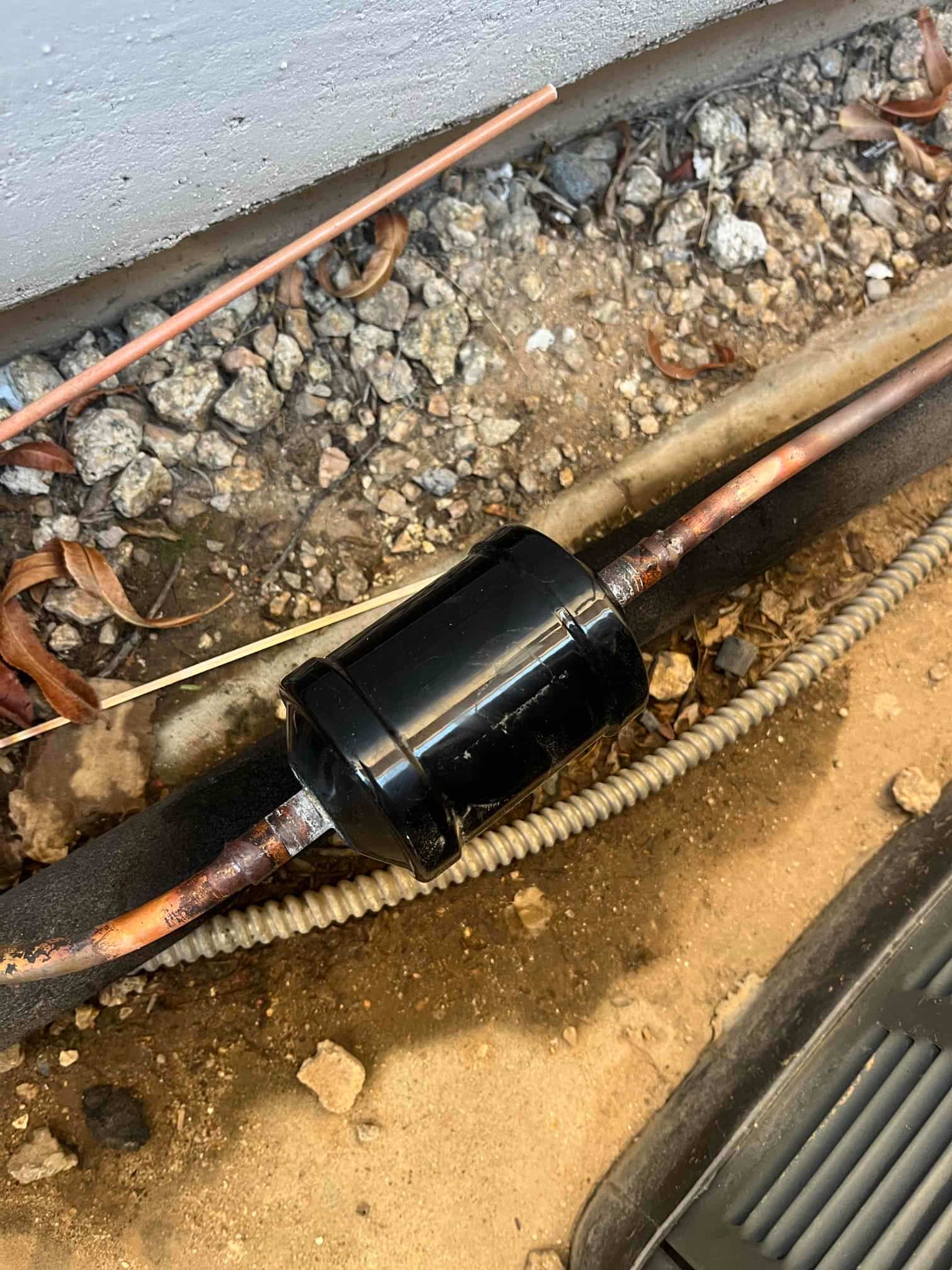 Bi-flow filter drier installed on the refrigerant line set, with clean brazed connections and surrounding insulation.