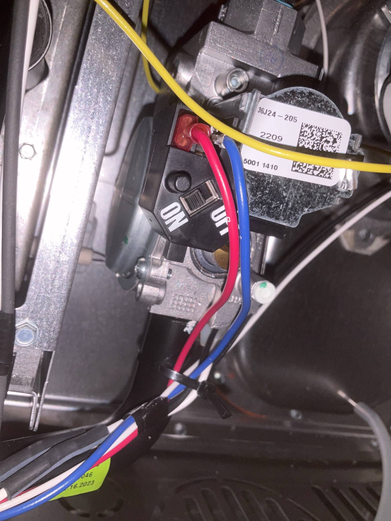 Close-up of furnace gas valve assembly with connected control wiring and manual ON/OFF switch inside the cabinet.