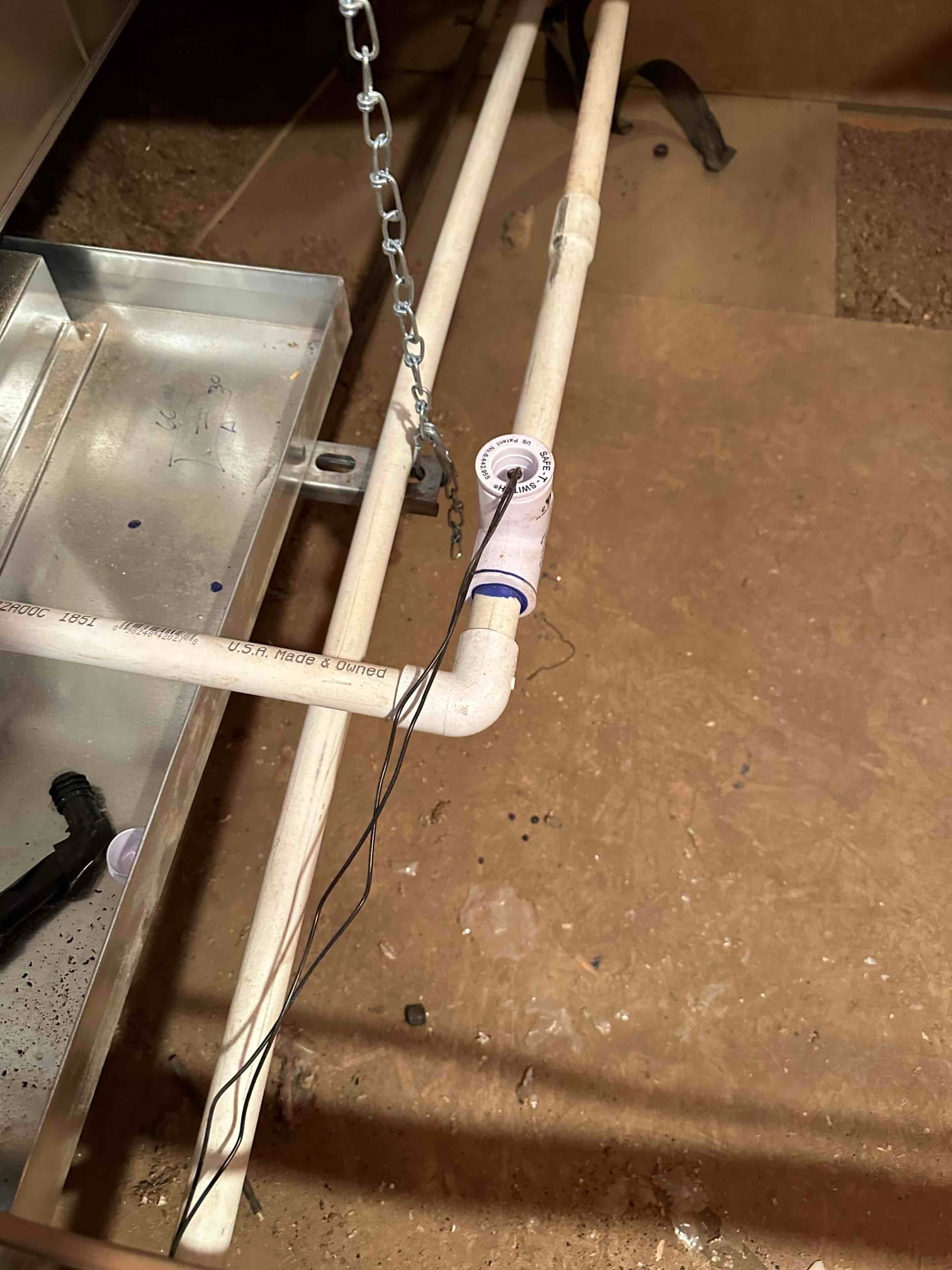 Condensate drain line with inline float safety switch wired to shut off the system, next to the auxiliary drain pan.