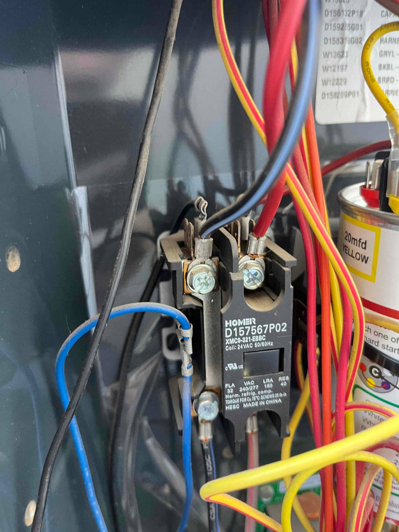Contactor with connected wiring inside the outdoor condenser compartment, next to a dual-run capacitor rated 45/5 μF.