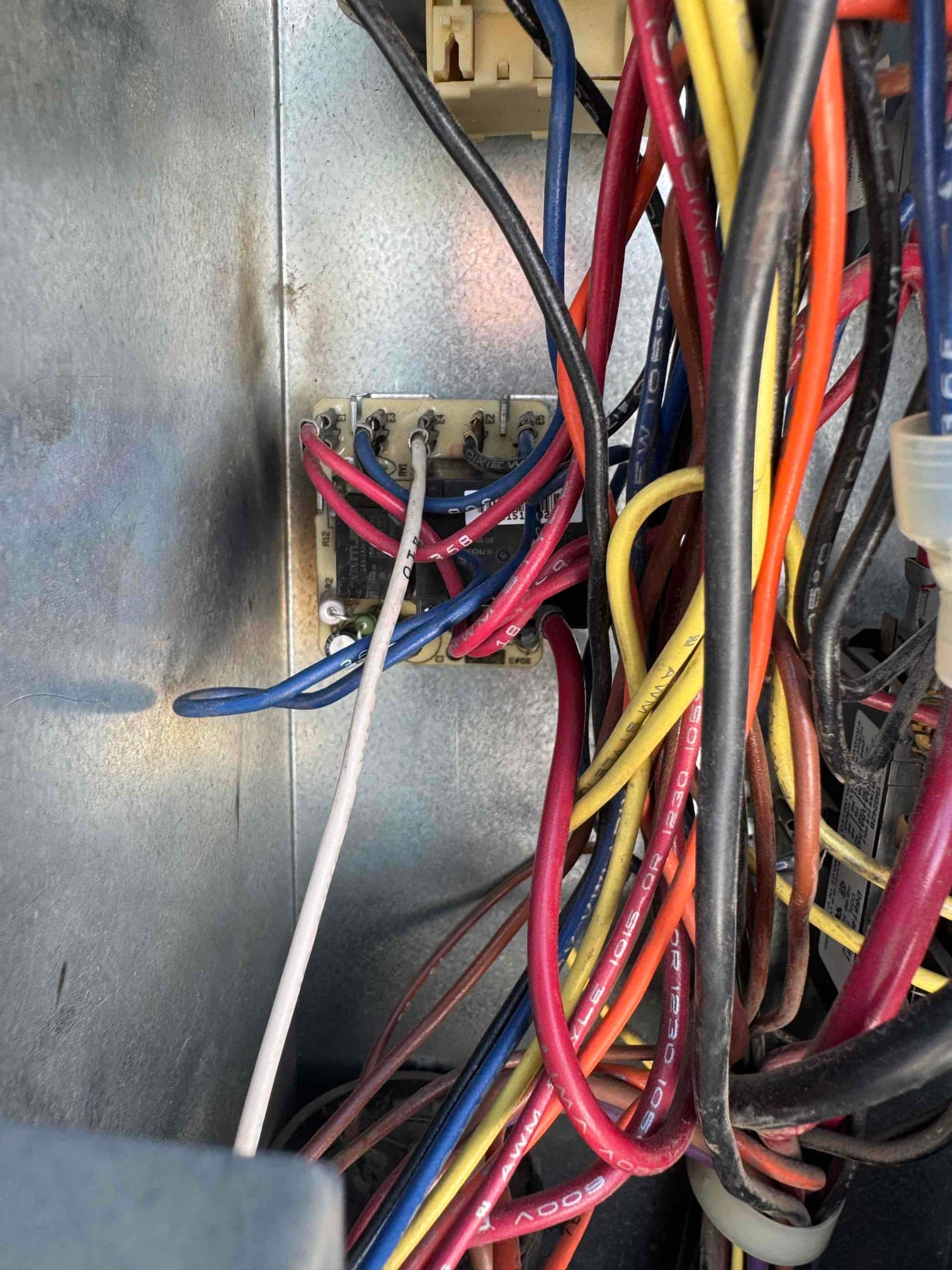 Control wiring inside an air handler cabinet, showing a terminal board with multiple colored conductors connected.