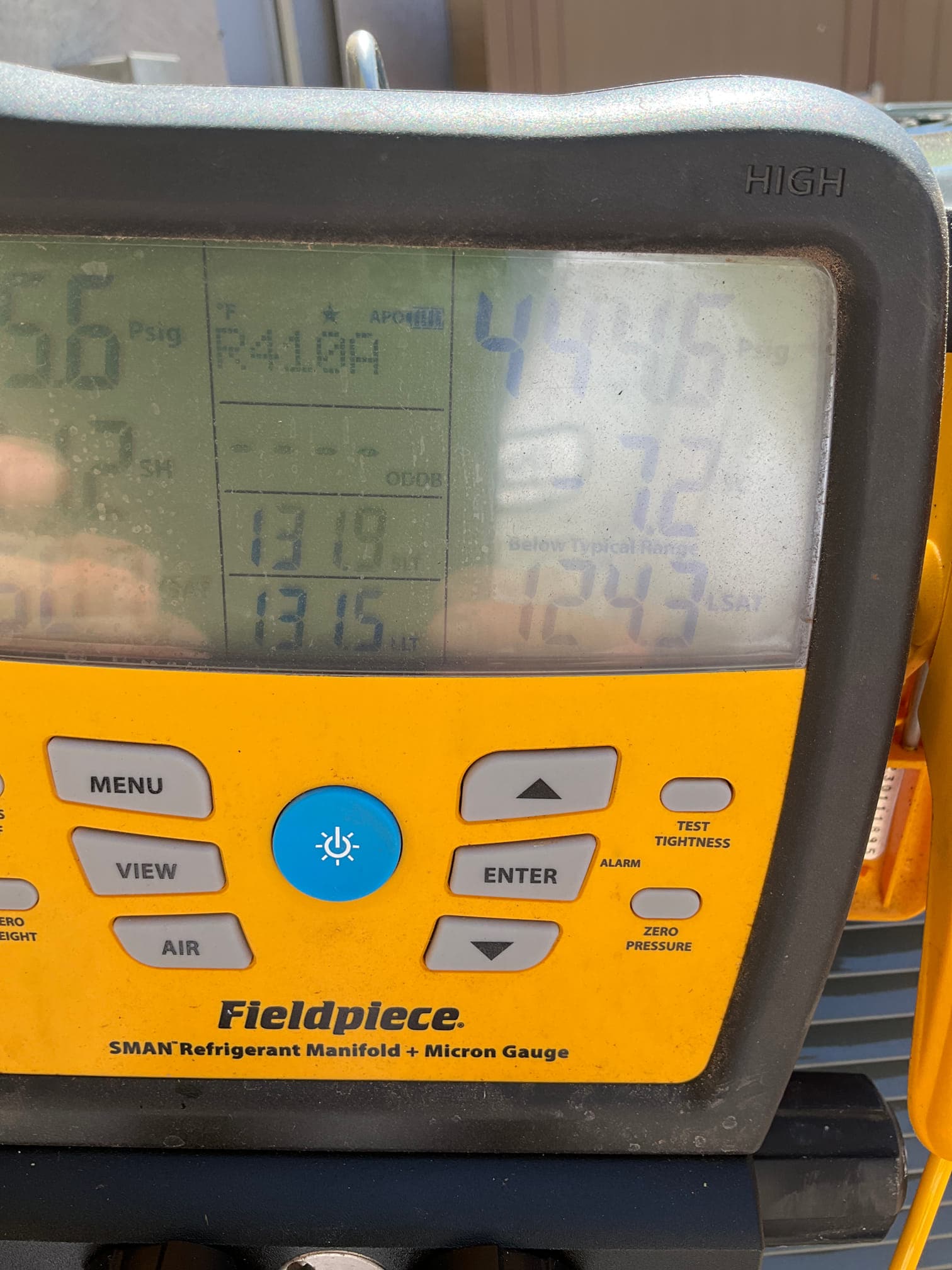 Digital manifold on the condenser shows R-410A with operating pressures during system commissioning.