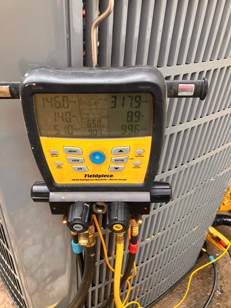 Digital manifold connected at the outdoor unit shows 146 PSI suction and 318 PSI liquid while the system runs.