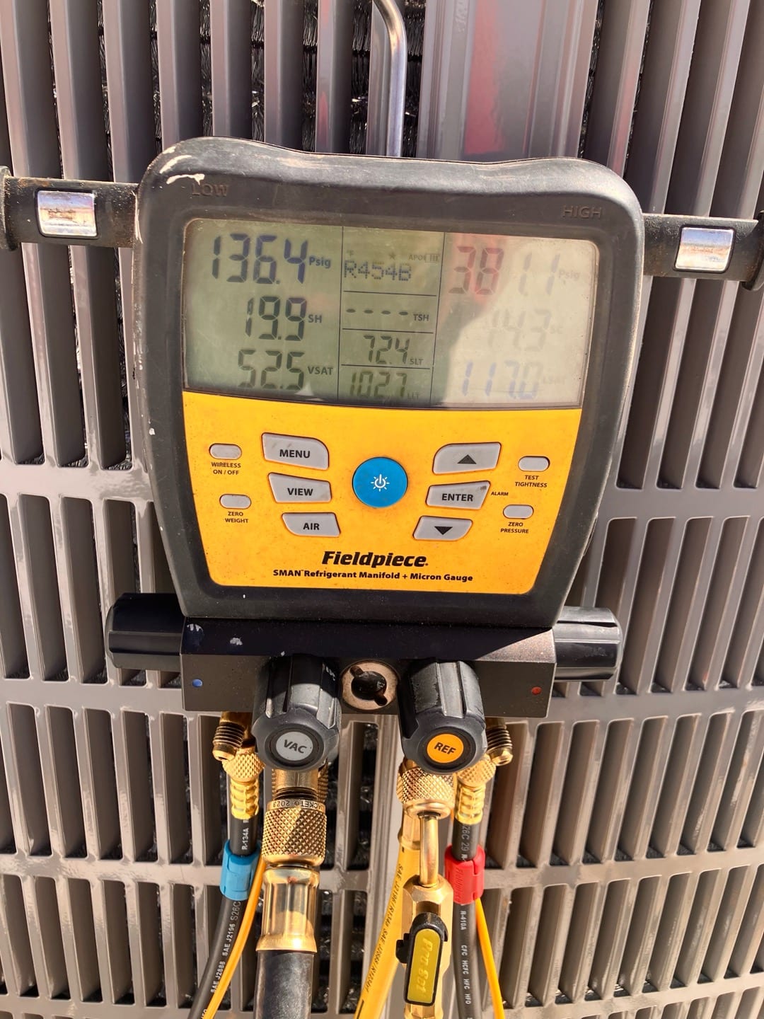 Digital manifold connected to the outdoor unit shows operating pressures and temperatures while the system runs with R-454B refrigerant.