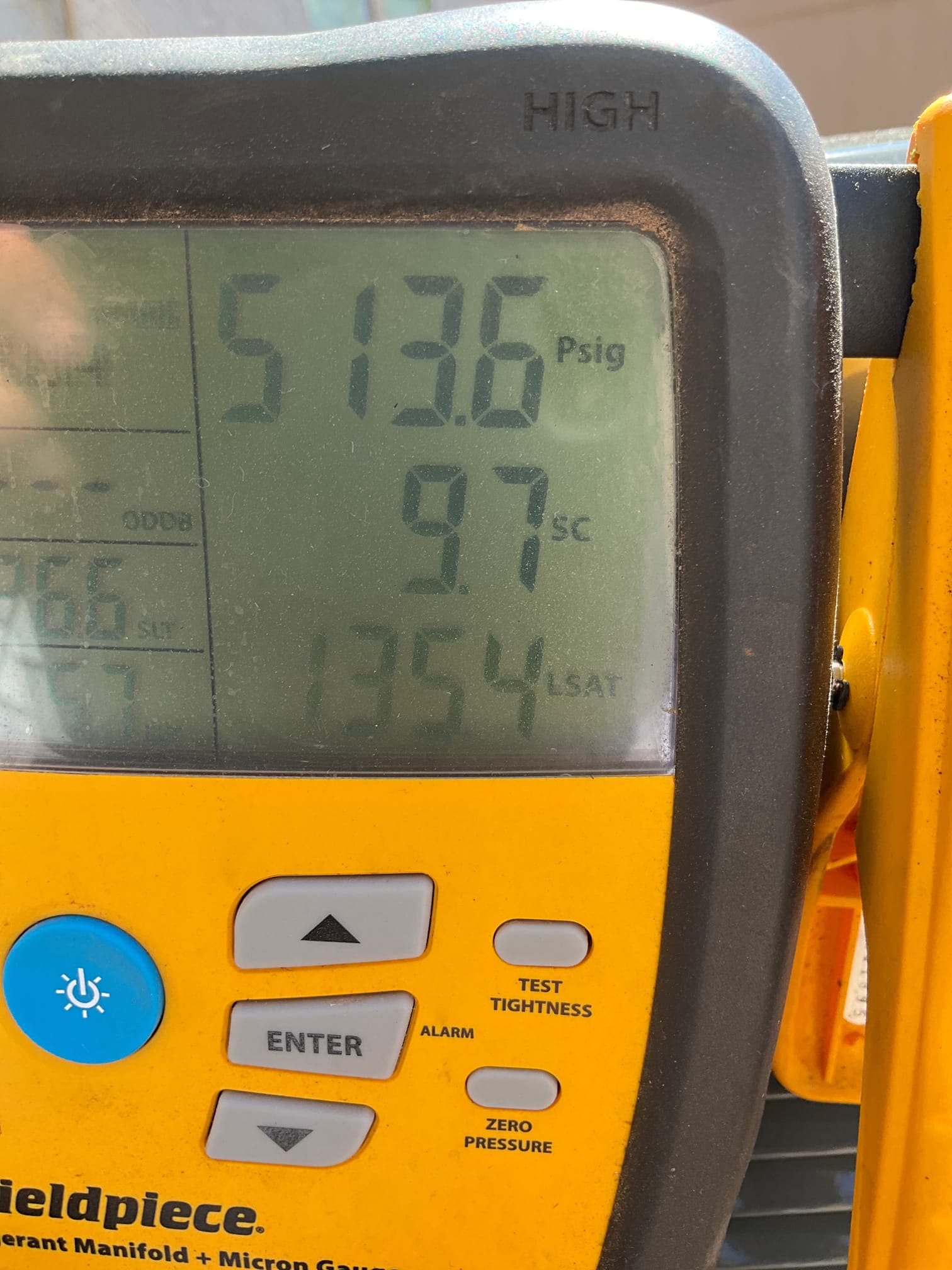Digital manifold display shows high-side pressure, subcooling, and liquid saturation temperature during system commissioning.
