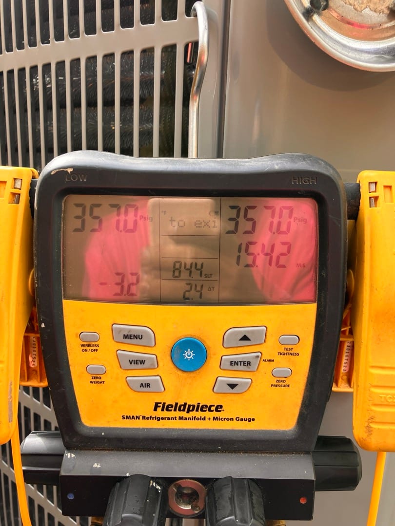 Digital manifold shows both high and low sides holding 357 PSI during a nitrogen pressure test at the outdoor unit.