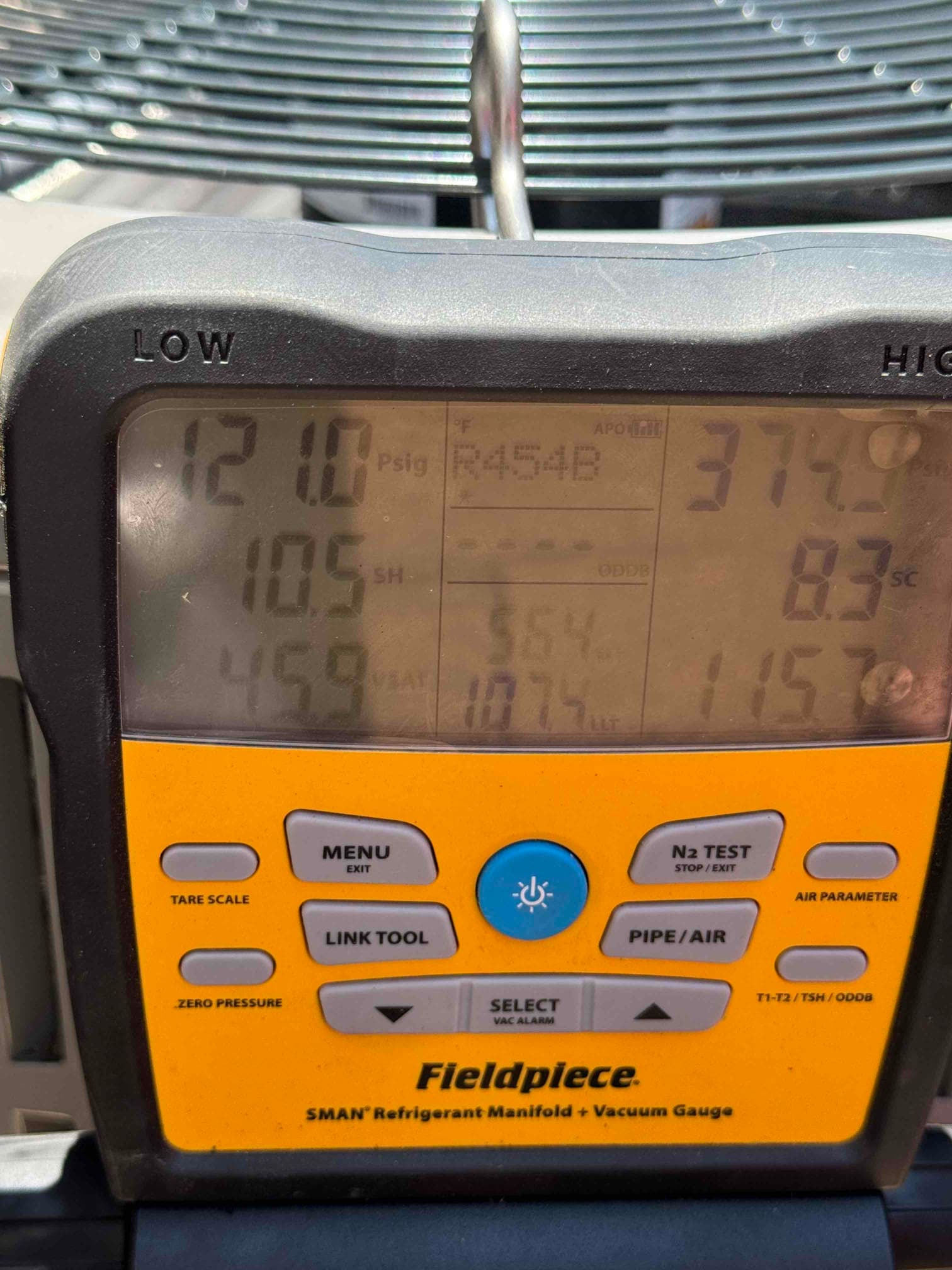 Digital manifold shows system operating pressures with R-454B selected, indicating active refrigerant commissioning on the outdoor unit.