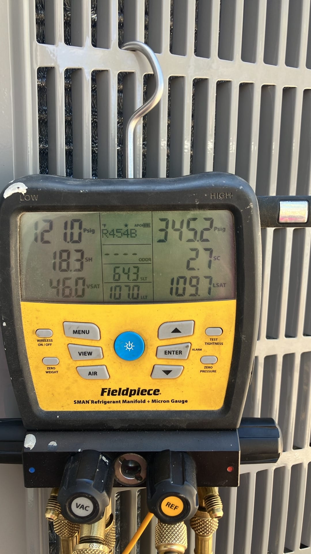 Digital manifold shows system operating pressures with low side at 121.0 PSI and high side at 345.2 PSI for R-454B.