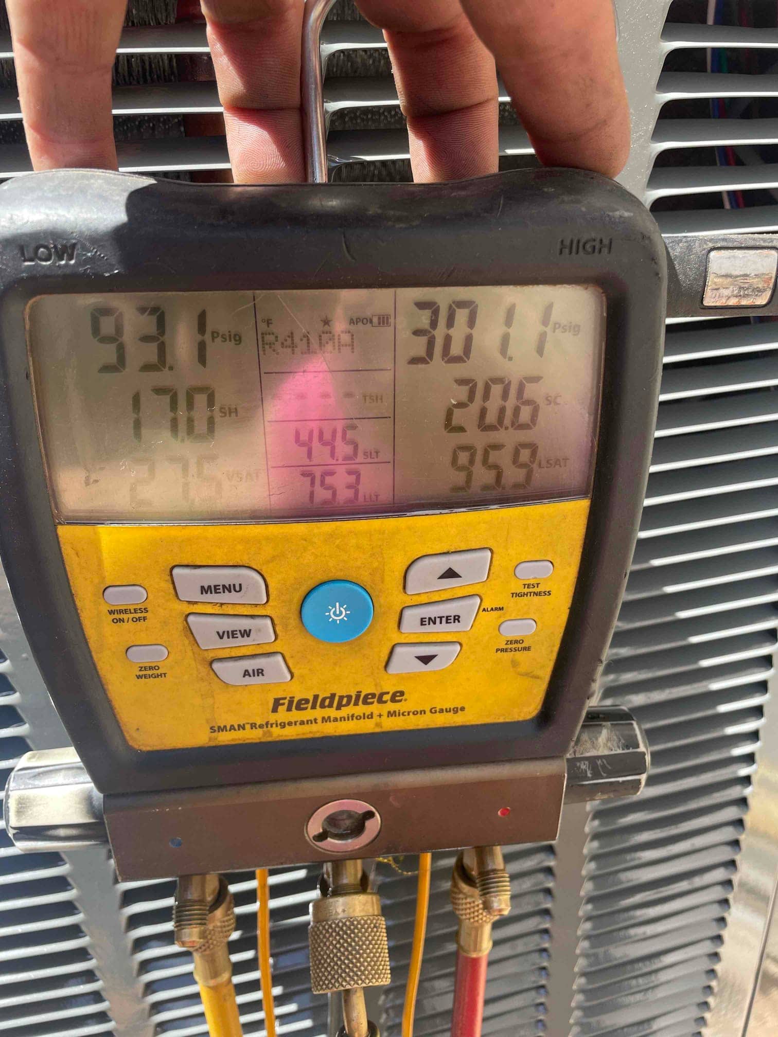 Digital manifold shows system operating pressures with superheat and subcooling while connected to the outdoor condenser.