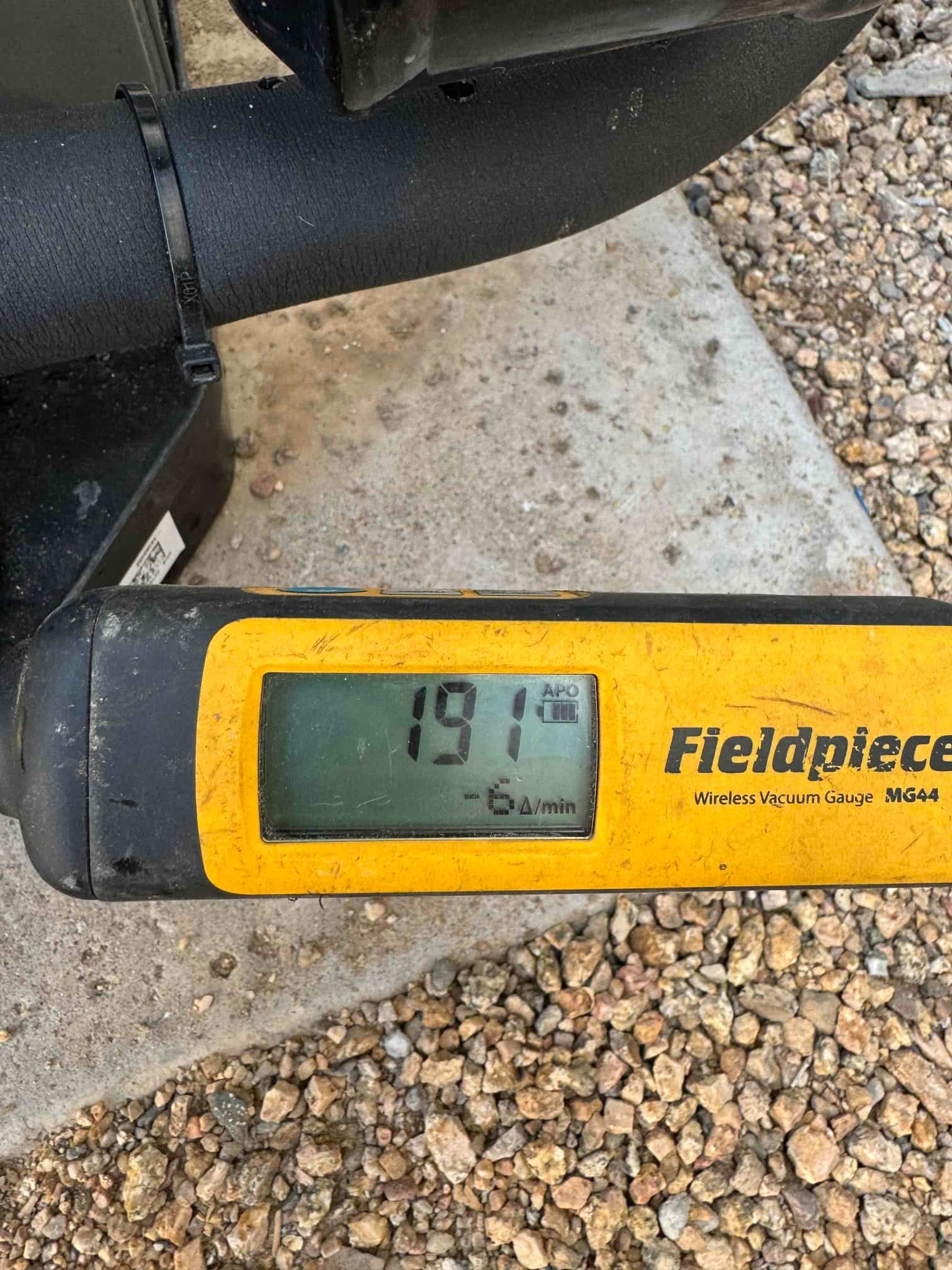 Digital micron gauge connected to insulated refrigerant line reads 191 microns during evacuation of the new system.