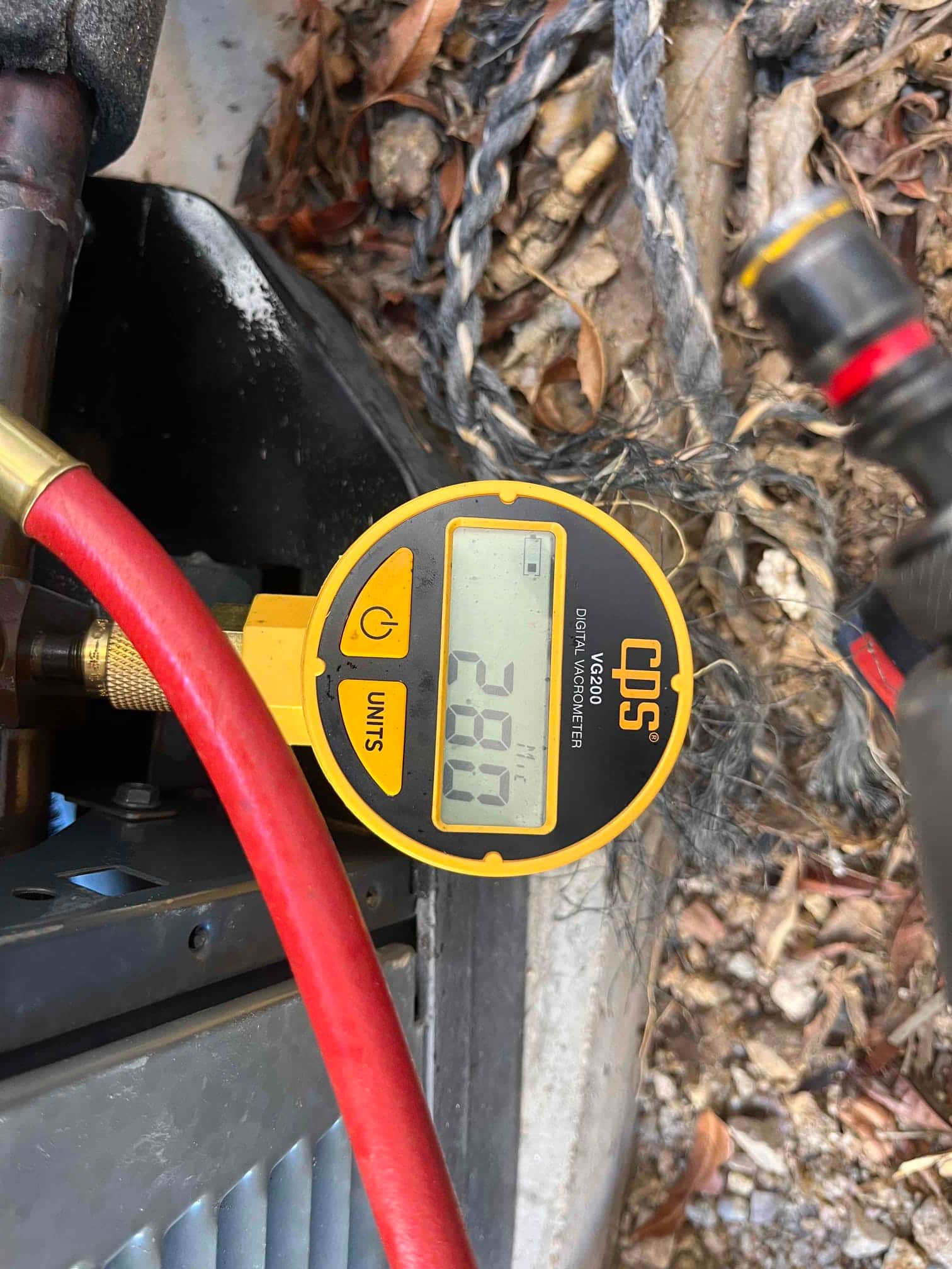 Digital micron gauge connected to the service port shows 2080 microns during system evacuation.