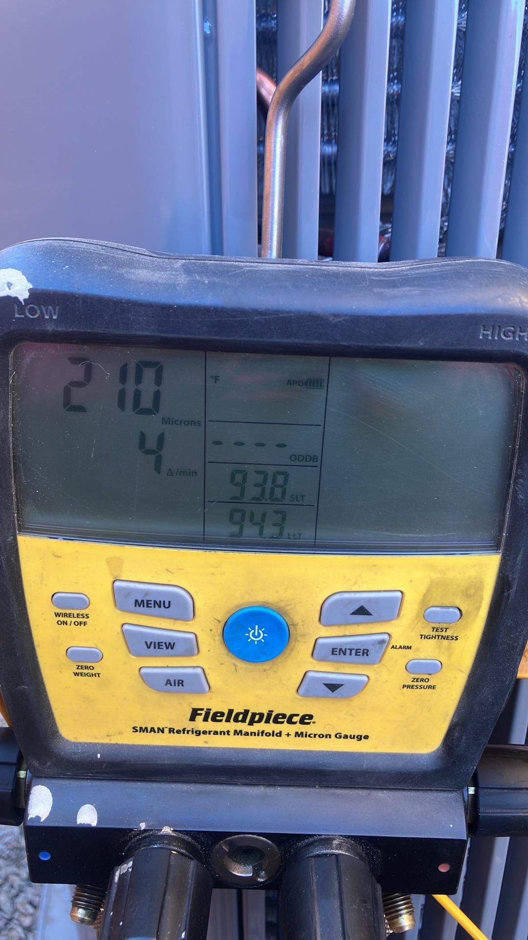 Digital micron gauge on the manifold shows 210 microns with a decay rate of 4 microns per minute during system evacuation.