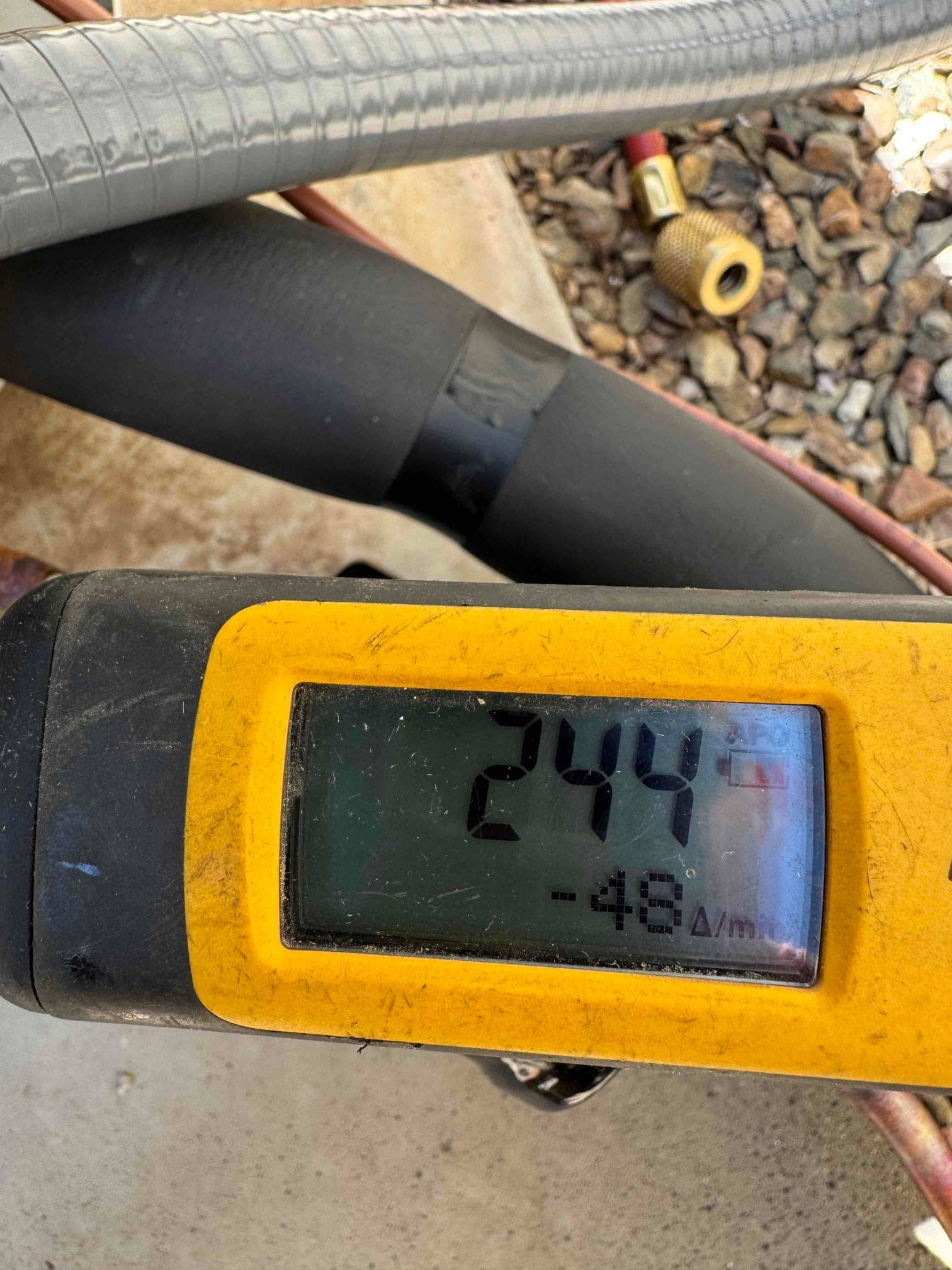 Digital micron gauge shows 244 microns during evacuation of the refrigerant lines before charging the system.