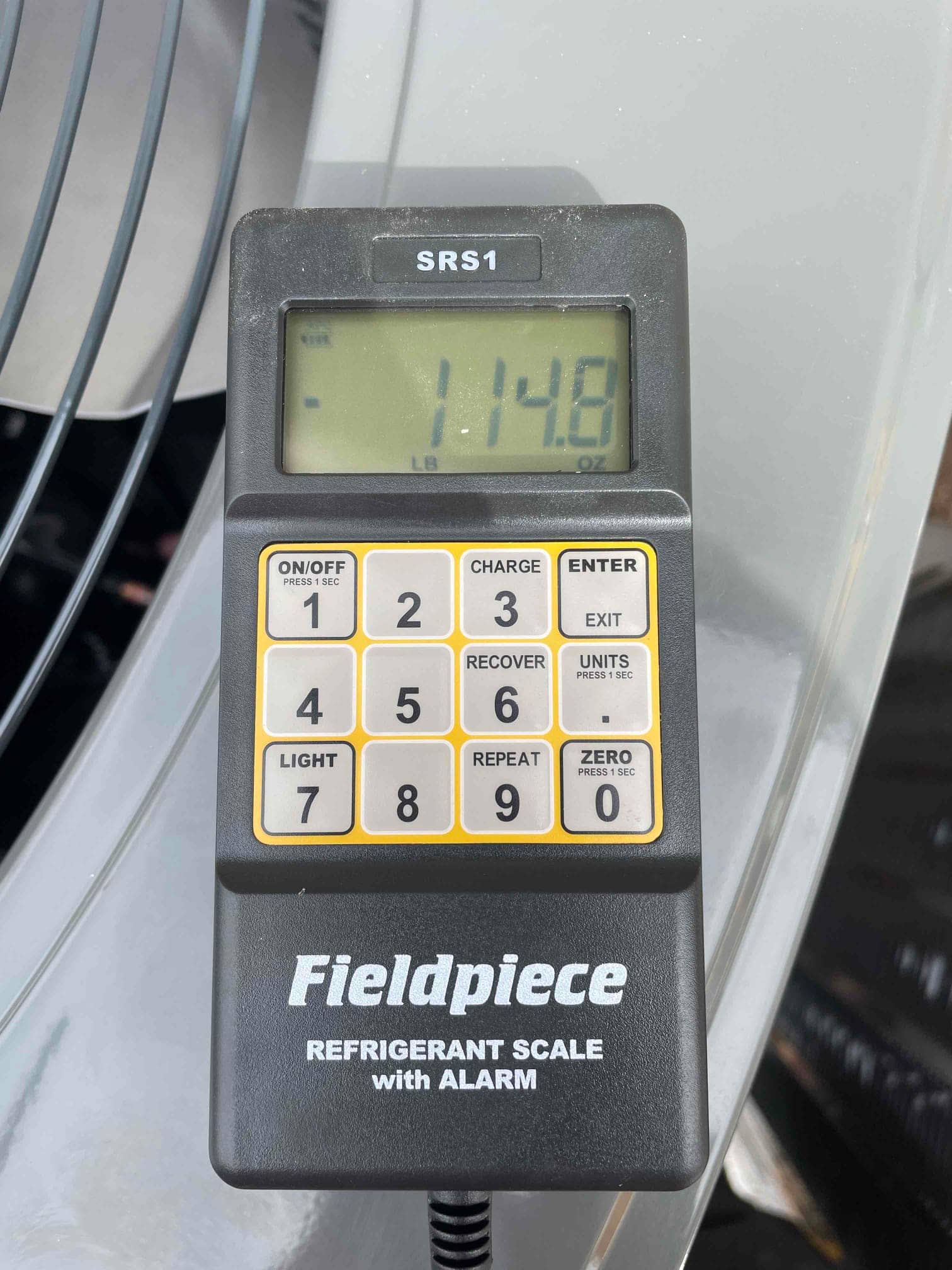 Digital refrigerant scale on the outdoor unit shows 11.48 pounds during charging of the new air conditioning system.