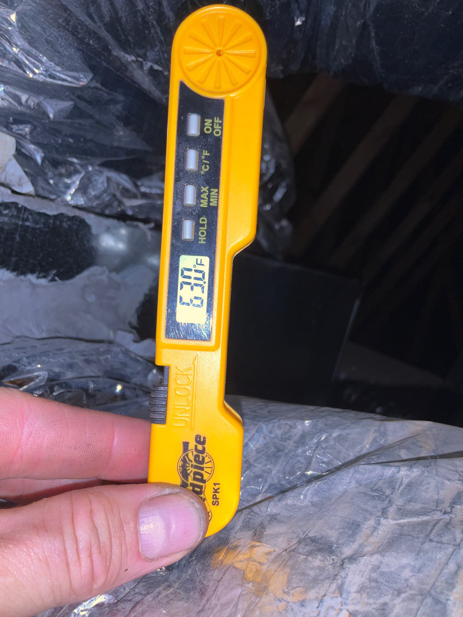 Digital thermometer probe measures supply air temperature at the duct, showing a cooled air reading of 53.0°F.