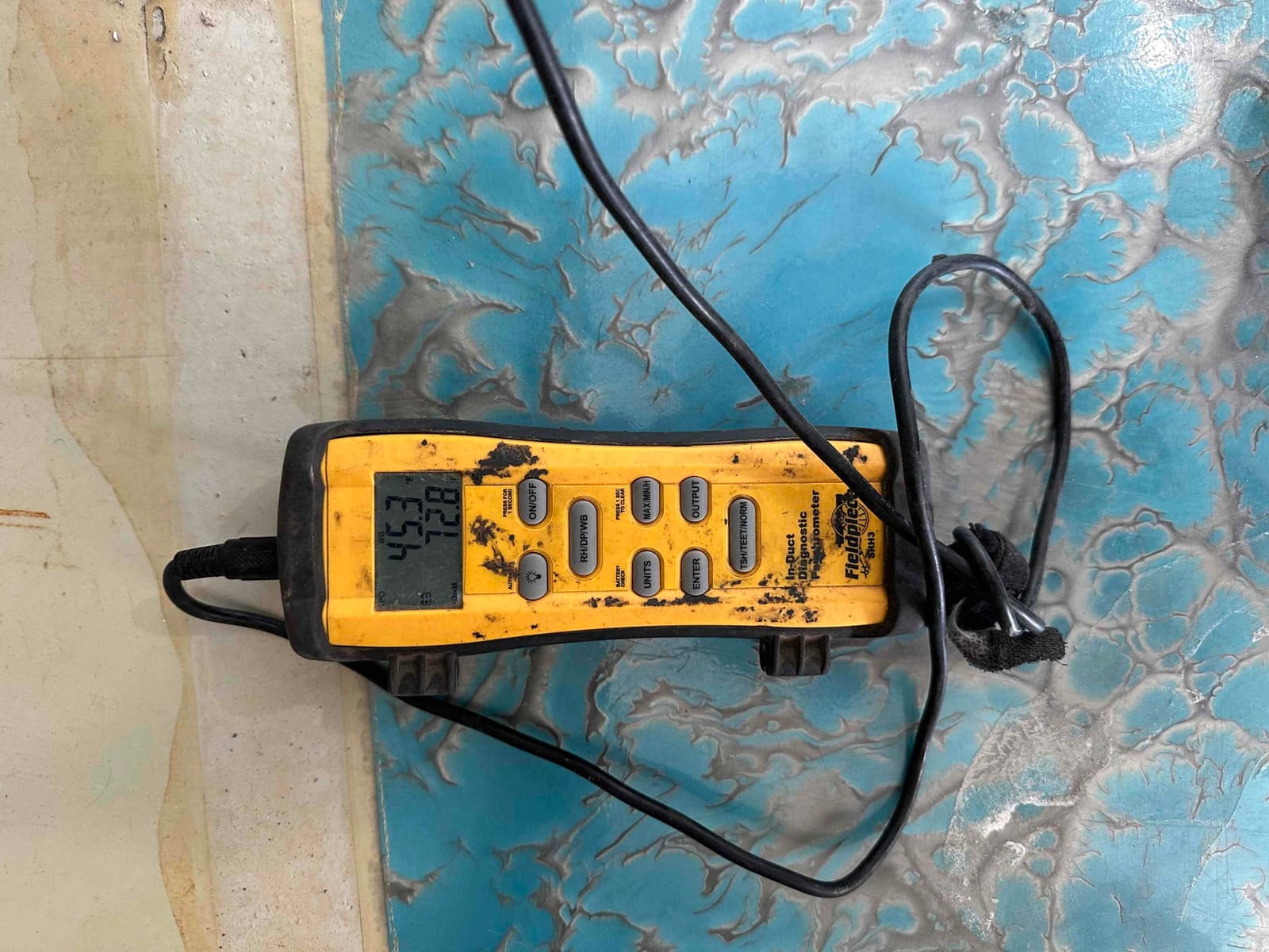 Digital thermometer with probe shows air temperature readings during commissioning of the HVAC system.