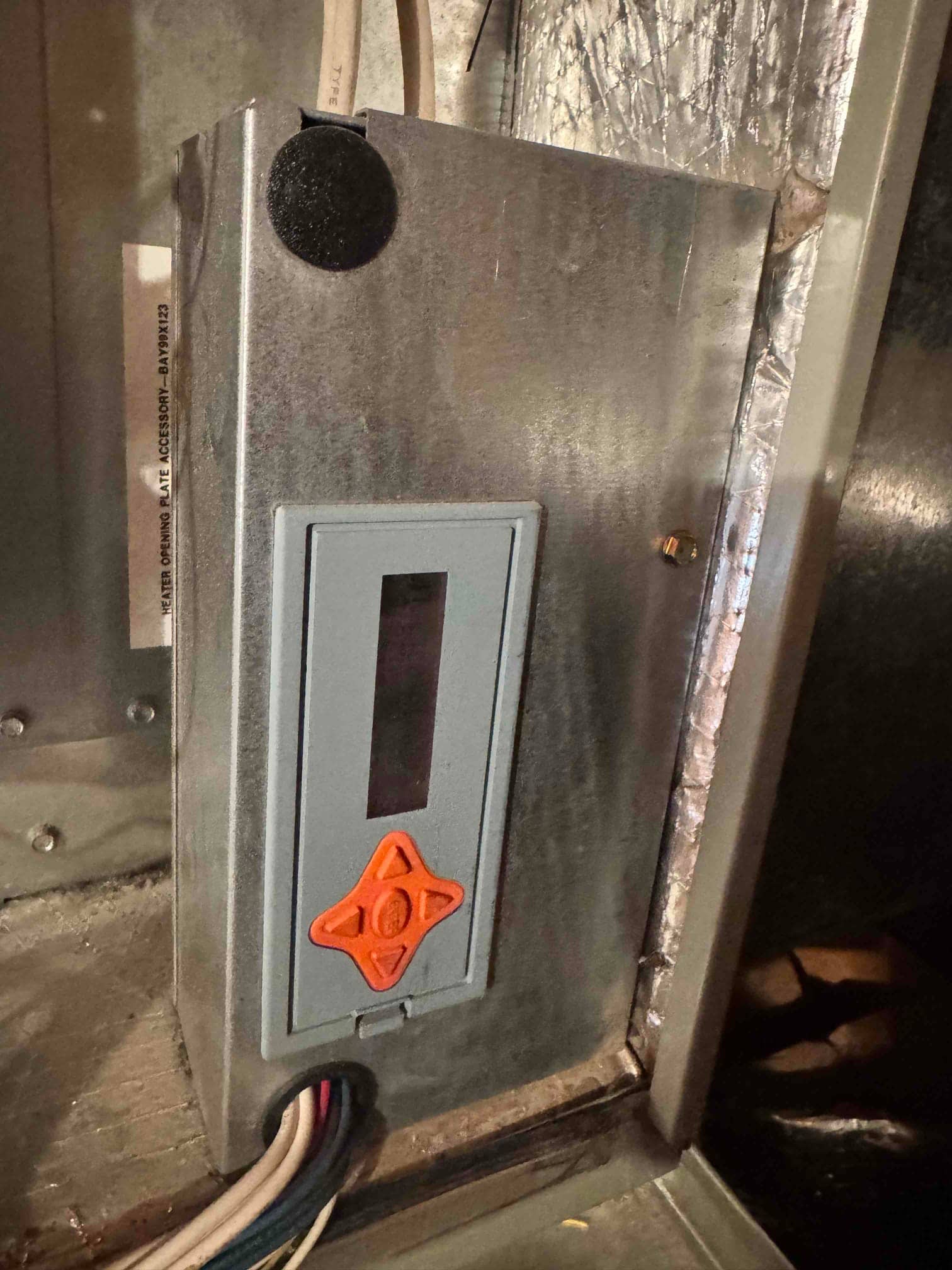 Electrical fuse holder inside the air handler cabinet, showing access cover and wiring leading into the enclosure.