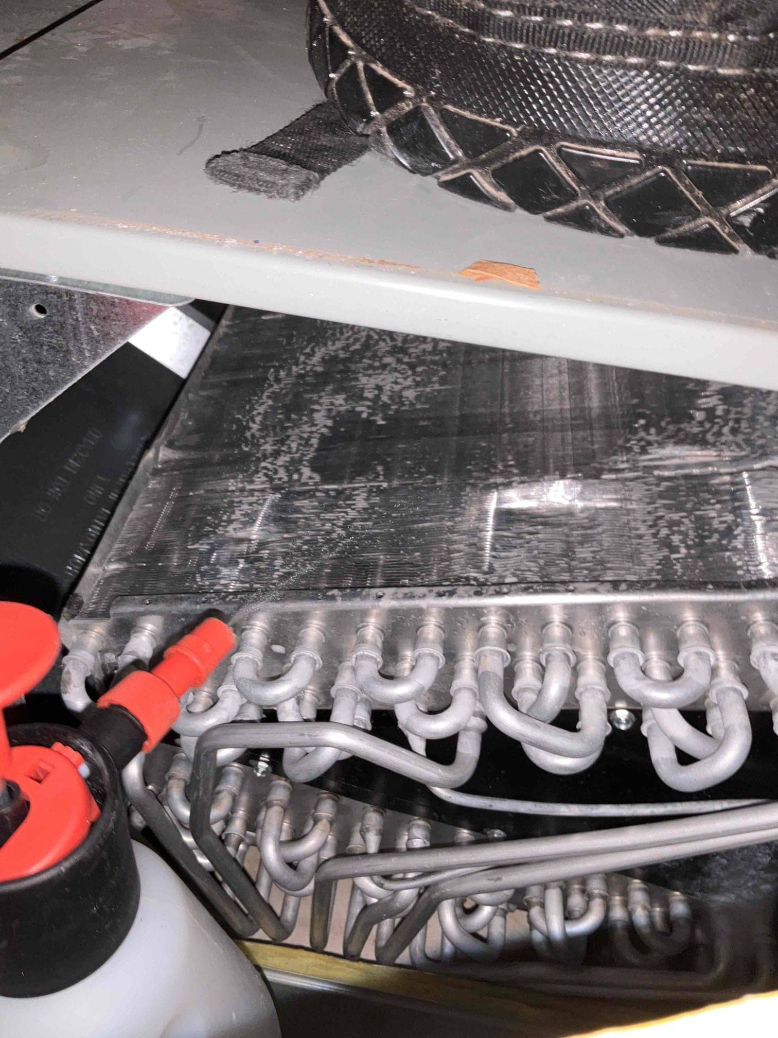 Evaporator coil assembly with exposed U-bends and fins inside the indoor unit cabinet.