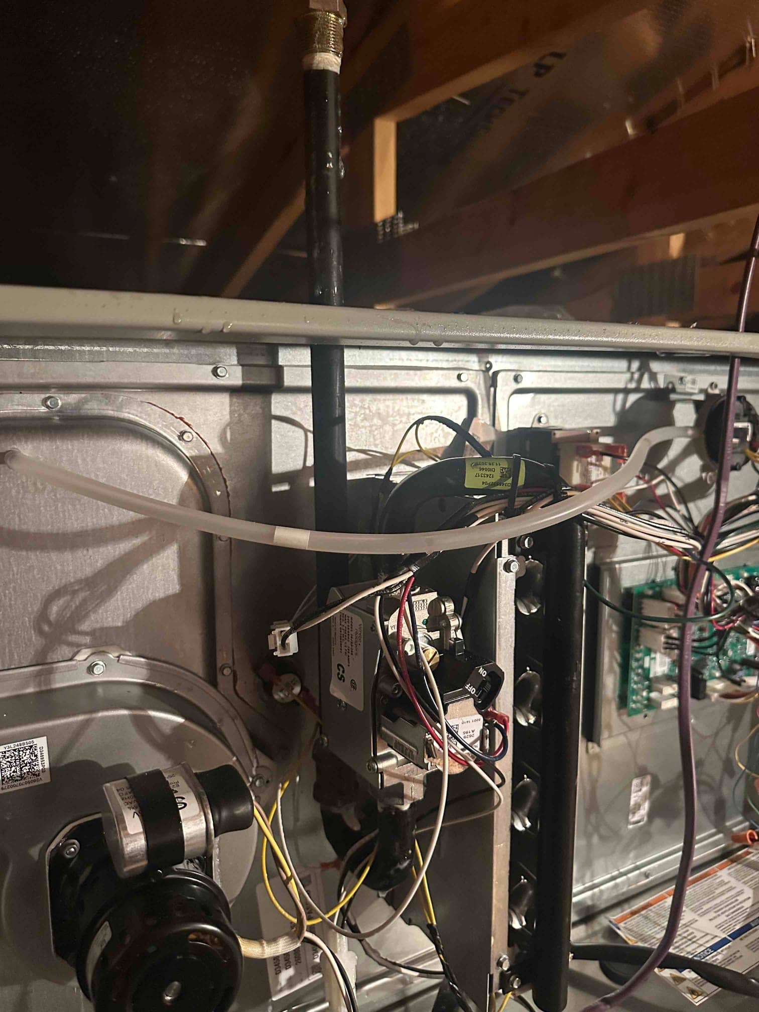 Furnace interior showing gas valve, burners, inducer motor, control board wiring, and connected gas line during installation.