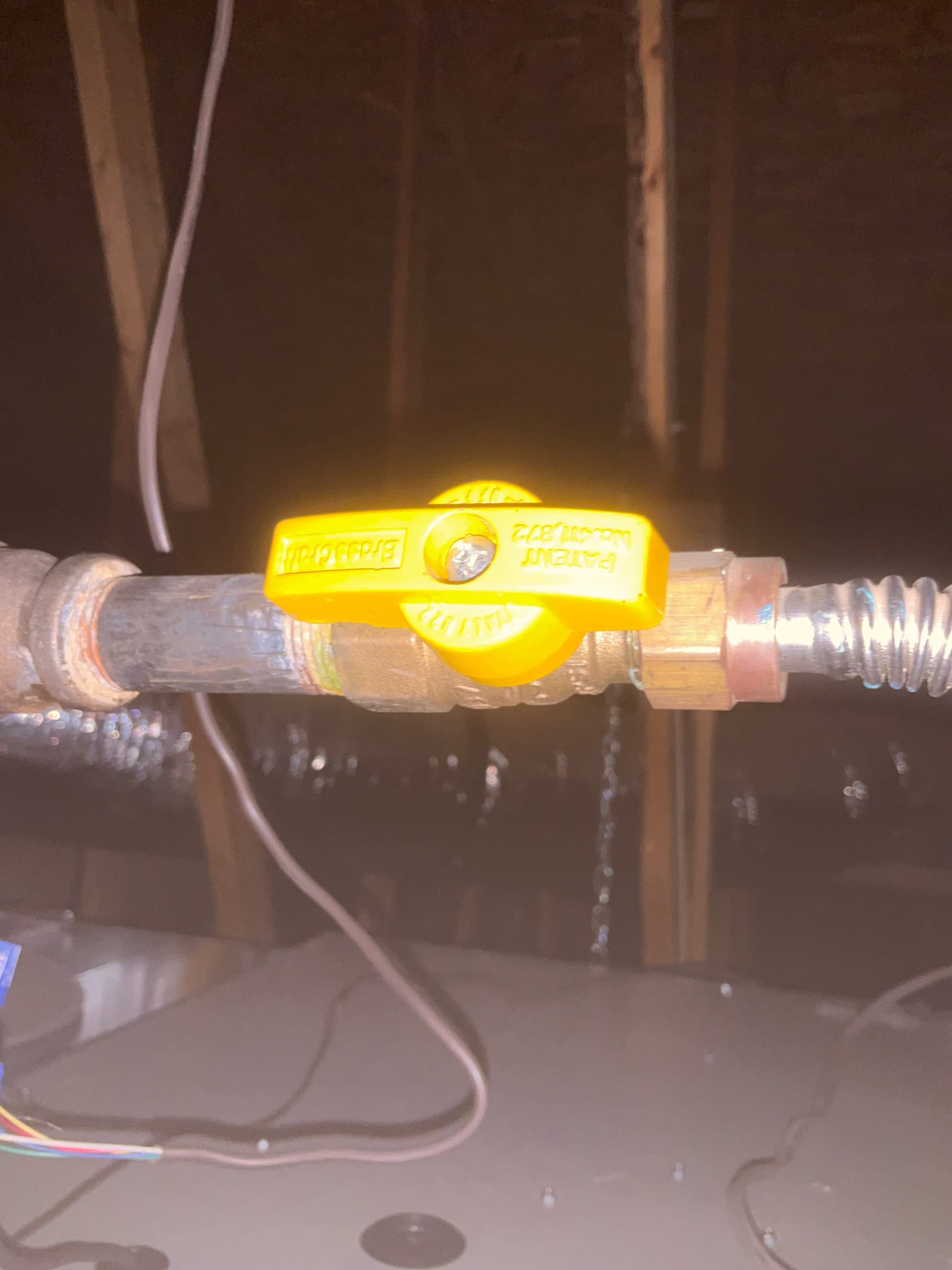 Gas shutoff valve installed on rigid-to-flex connector above the air handler in the attic.