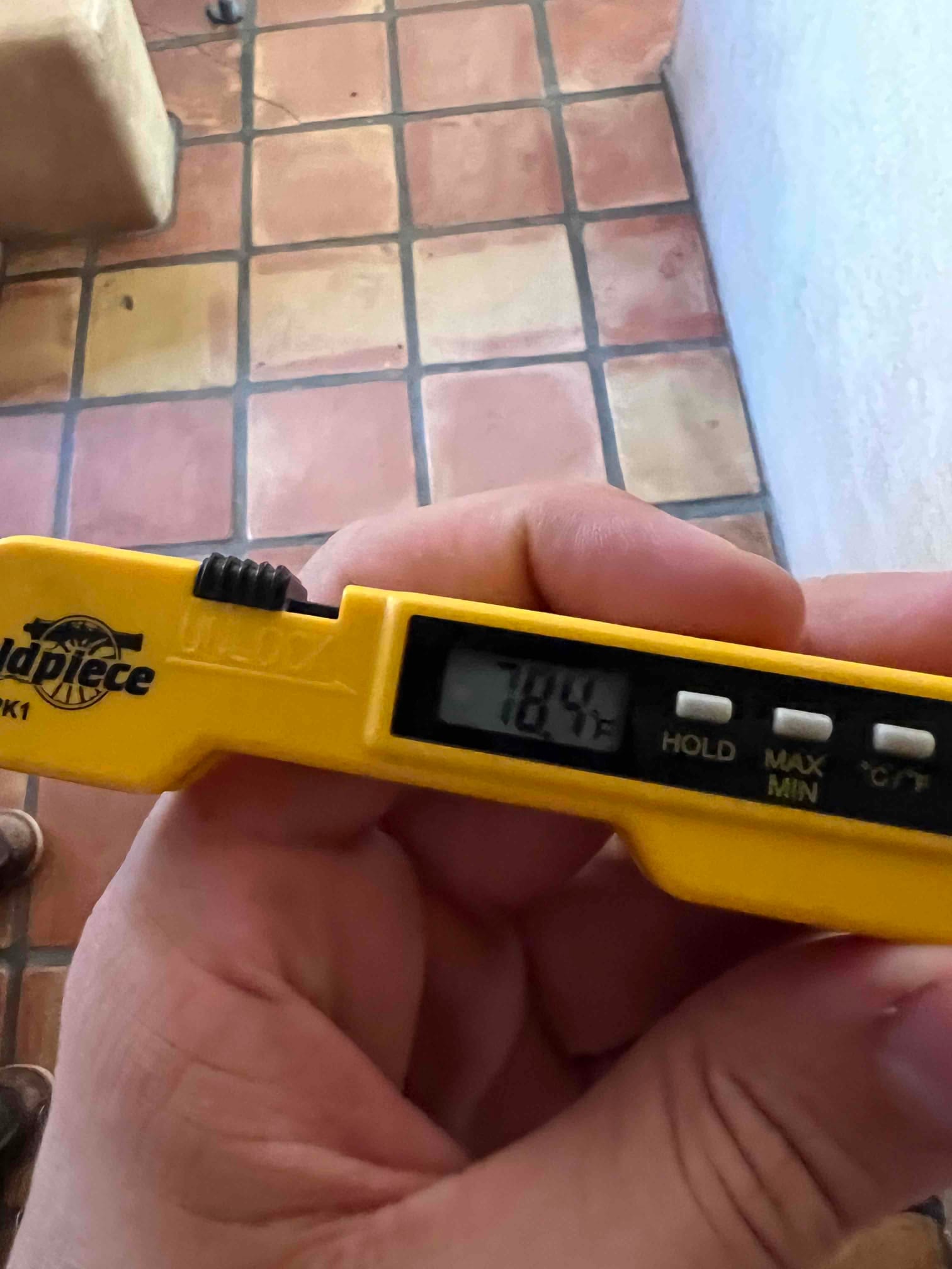 Handheld digital thermometer displays 78.4 degrees Fahrenheit during return air temperature check for the newly installed system.