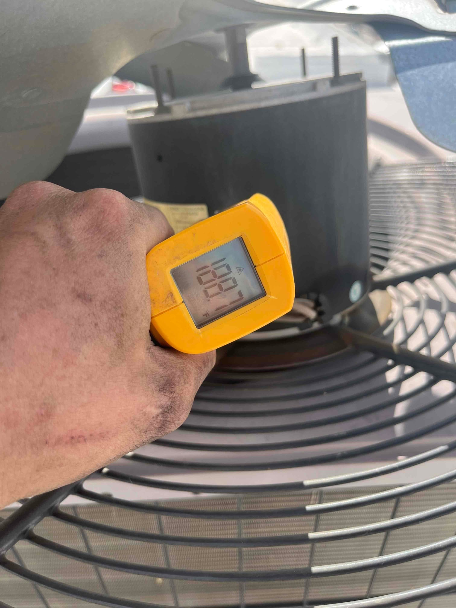 Infrared thermometer reads 108.1 °F on the condenser fan motor housing during operation after ECM replacement.