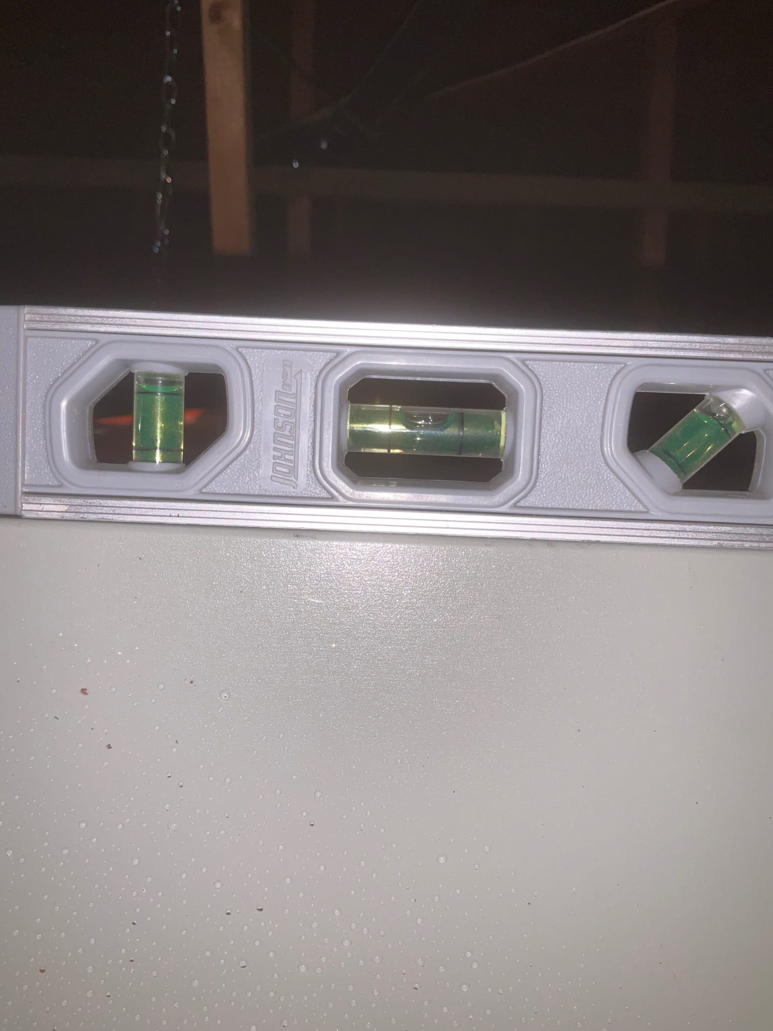 Level placed on top of HVAC equipment cabinet to verify the unit is set level during installation.